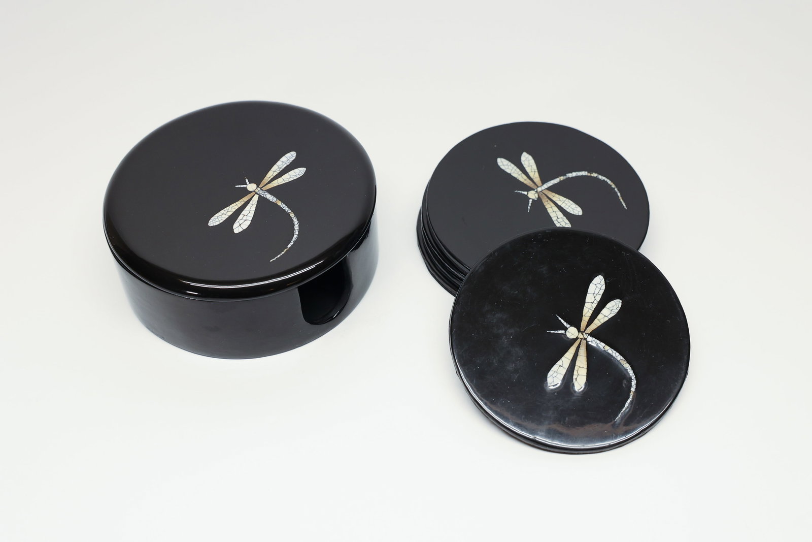 Asian Black Lacquer Coaster Set, Inlay Dragonfly: Condition Report:The coasters show general surface wear with light scattered scratching to the black lacquer finish, consistent with normal use. One coaster shows a hairline crack extending from the