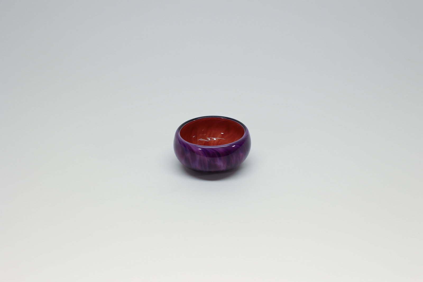 Blowing Sands Studio Art Glass Dish, Signed 2016: Hand-blown art glass bowl with a deep purple exterior over a vibrant orange-red interior with radiating pulled-cane pattern, rolled rim. Signed and dated on the base "[artist name], 2016, Blowing