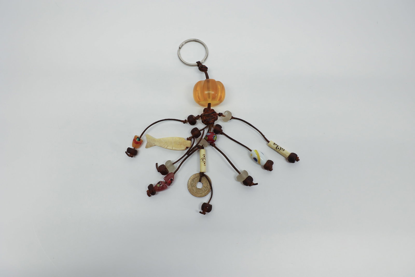 Ethnic Beaded Keychain w/ Chinese Coin & Charms: Decorative multi-strand keychain fob featuring an amber-toned faceted resin or glass bead at the top, with a cluster of leather cords fanning out below, each strung with an assortment of beads and cha