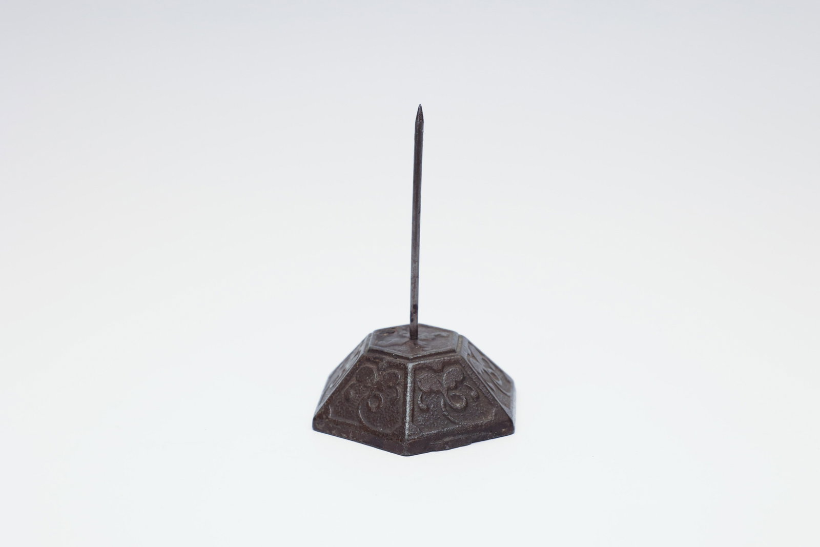 Antique Cast Iron Receipt Spike, Ornate Base: Antique cast iron receipt spike, featuring a tall central steel spindle mounted on a hexagonal pyramidal base decorated on each panel with a raised scrolling foliate design. These spikes were a