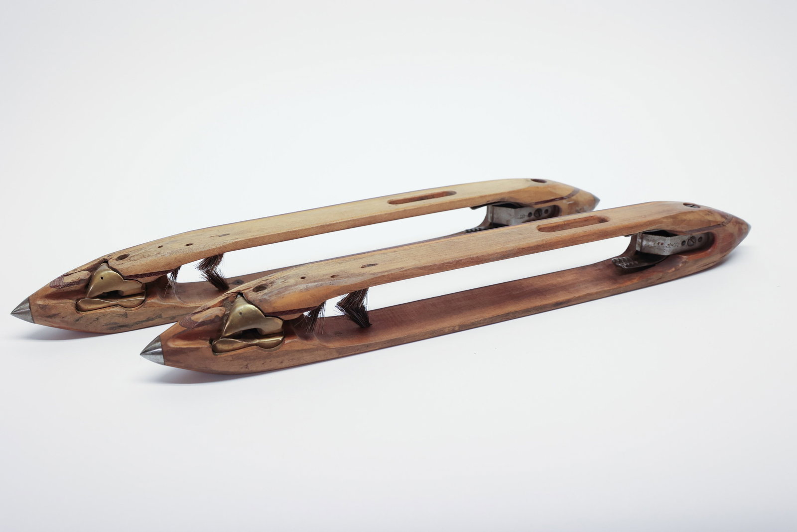 Pair of Wooden Loom Shuttles: Pair of wooden weaving loom shuttles with pointed metal tips at each end, brass tensioner clips, and spring-loaded bobbin holders housed in the open center cavity. Natural wood with worn, aged patina 