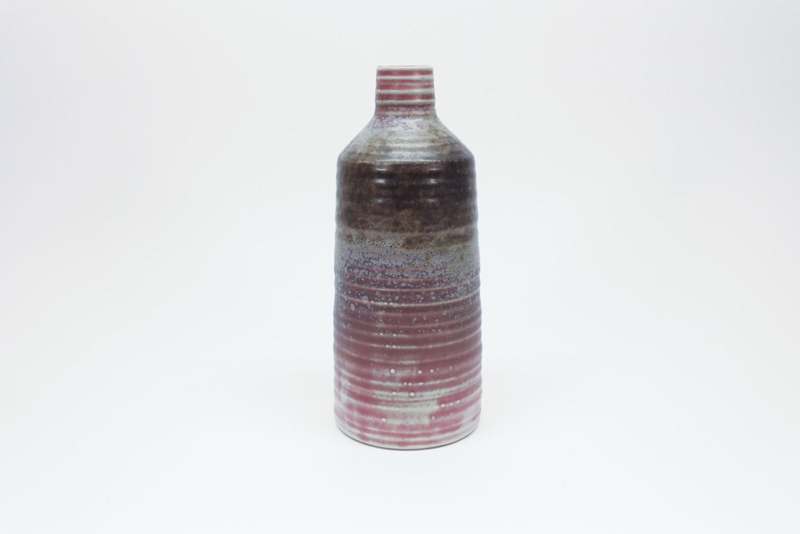 Studio Pottery Bottle Vase, Ash Glaze Bands: Hand-thrown studio pottery bottle vase with a narrow banded neck opening into a tall cylindrical body, finished in a striated ash or salt-glaze effect that shifts from a dark charcoal band at the