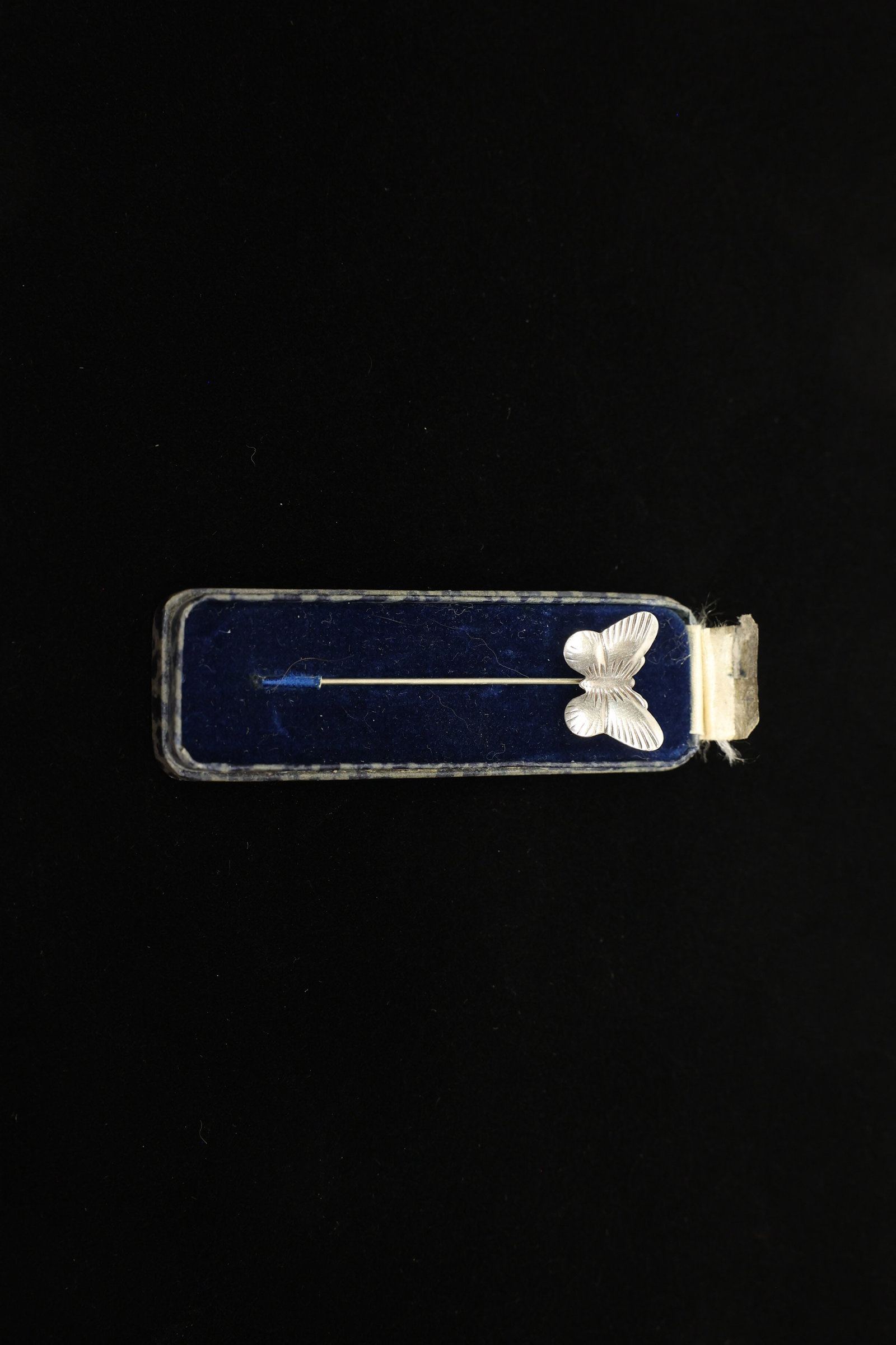 Sterling Silver Butterfly Stickpin, Orig. Box: A delicate sterling silver stickpin topped with a finely detailed butterfly, its four wings hand-finished with fine radiating ridges to suggest wing veining and movement. The piece retains its origina