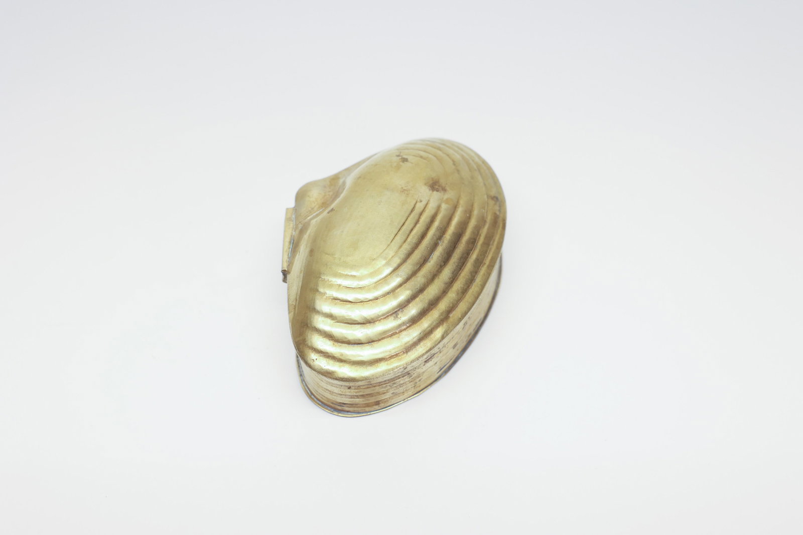 Vintage Brass Clamshell Hinged Trinket Box: This charming trinket box, measuring 1.75" H x 2.75" W x 4" L, is cast in solid brass in the naturalistic shape of a bivalve shell, with deeply ribbed growth lines radiating across both the domed lid 