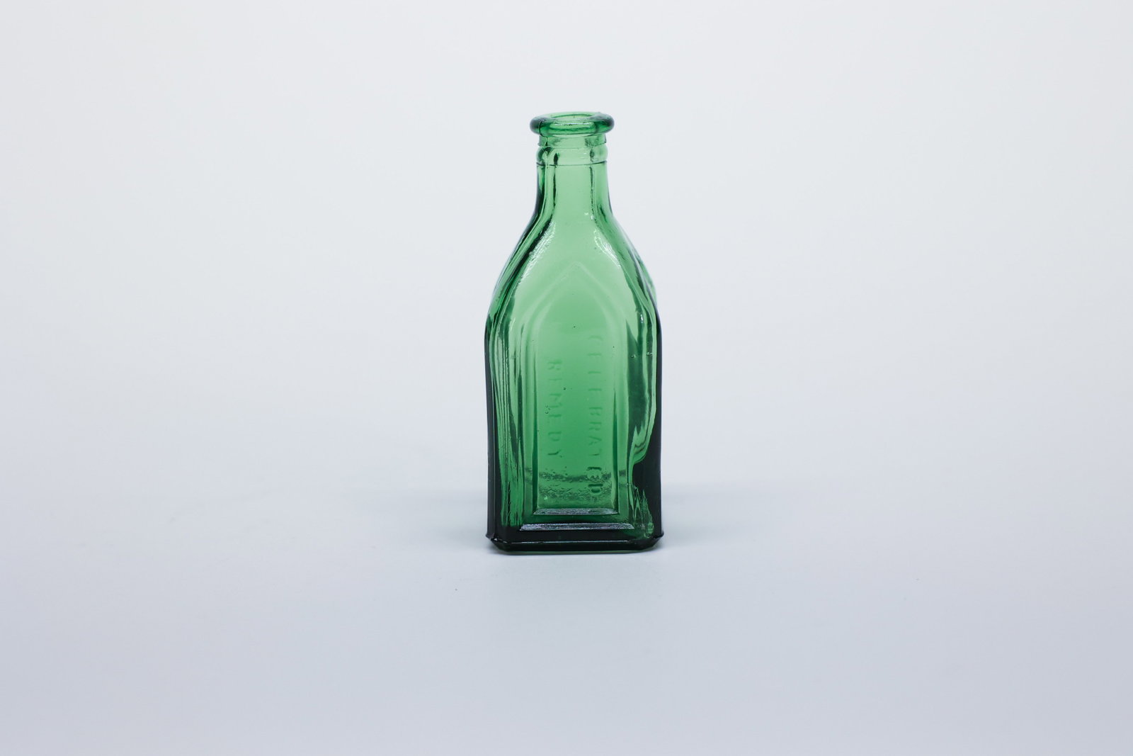 Cathedral Bottle, Chief Wahoo Tonic, Dunsmuir CA: This small 3" bottle in glowing green glass is a classic "cathedral" style medicine bottle, so named for the tall, pointed Gothic-arch panels embossed into its sides, a decorative bottle form popular 