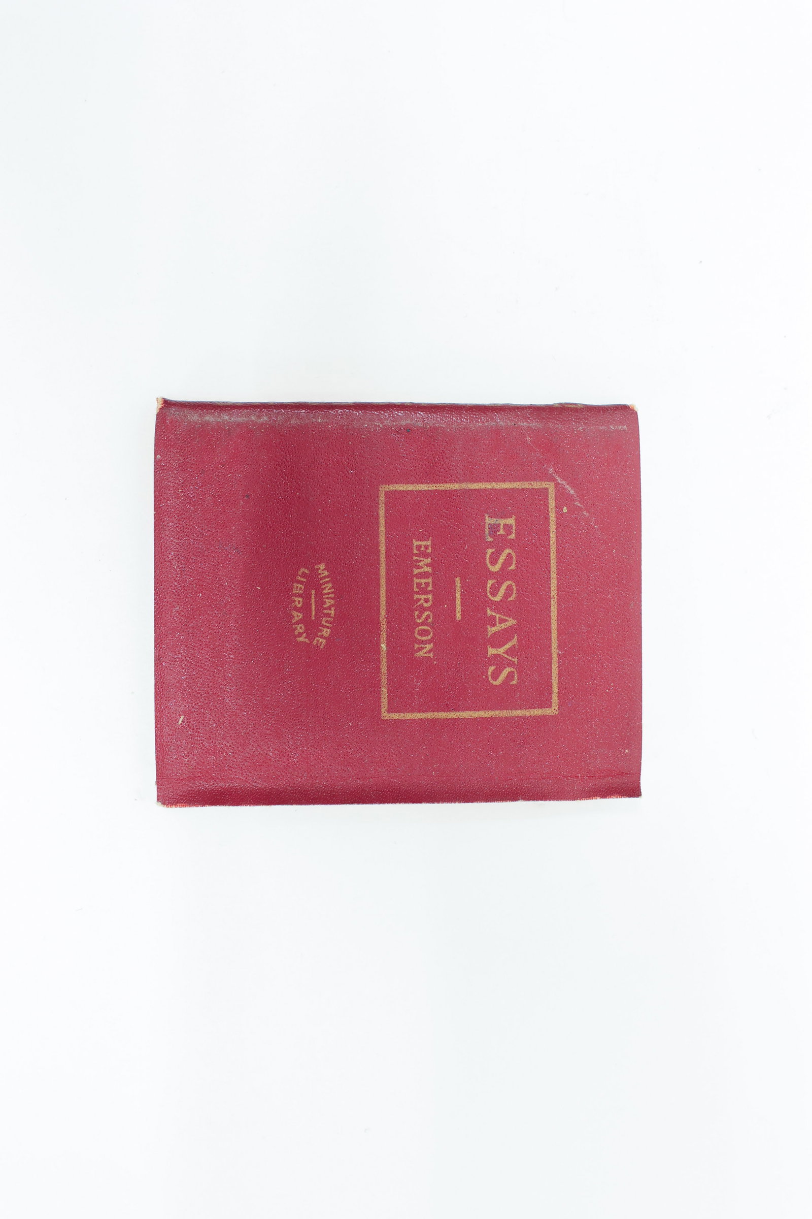 Miniature Library, Emerson's Essays, Red: A small, richly colored red leatherette-bound edition of "Essays" by Ralph Waldo Emerson, with the title stamped in gilt within a decorative border on the front cover and "Miniature Library"