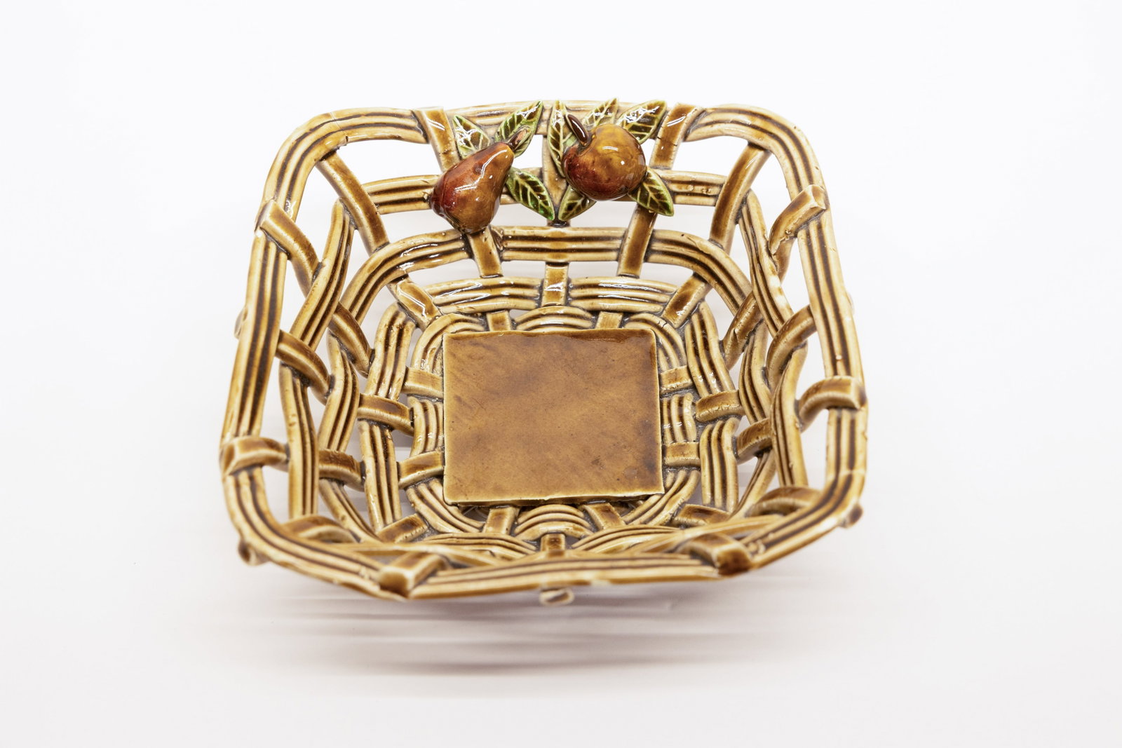 Spanish Majolica Basket Weave Dish with Pear Apple: Description:Glazed ceramic dish molded and glazed to resemble a woven wicker basket, in an amber/brown glaze with a fine lattice basket-weave texture and scalloped open sides. Two applied,