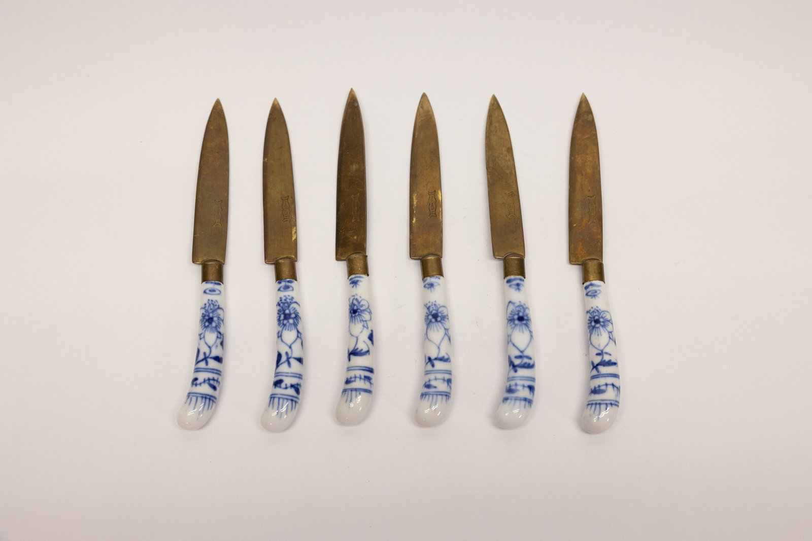 Rheingold Blue Onion Fruit Knives, Set of 6: Description:Set of six fruit knives with brass-toned blades stamped with a small lyre-form maker's mark, each fitted with a porcelain handle decorated in the classic blue-and-white "Blue Onion"