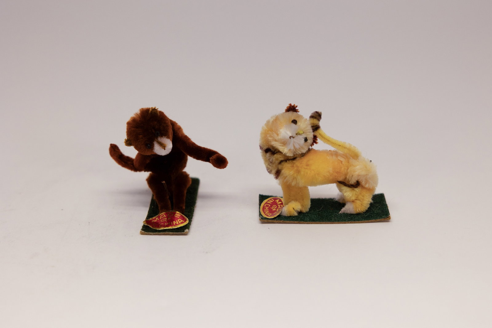 Vintage Miniature Mohair Monkey & Lion Figures: Description:Pair of miniature novelty animal figures, a monkey and a lion, each formed from mohair or plush fiber over a wire armature, with hand-stitched felt facial details and glass or bead eyes.