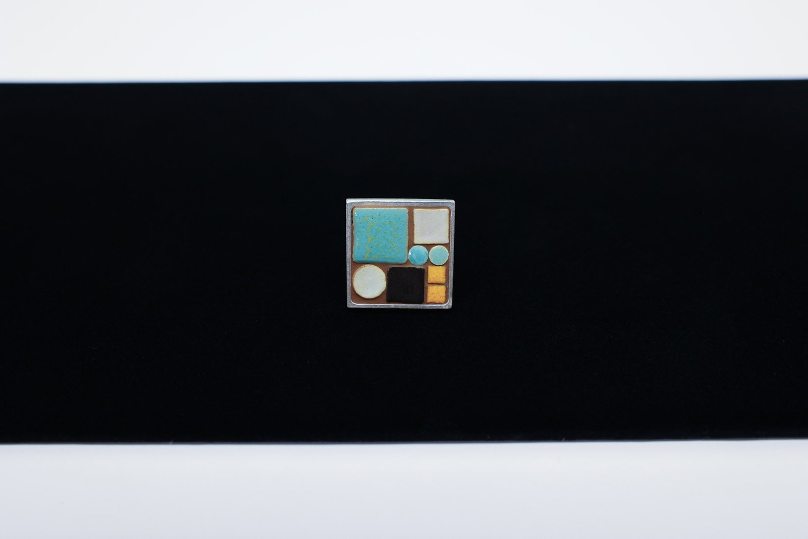 Modernist Sterling Silver Enamel Tile Ring: Description:Handcrafted artisan ring with a square silver face composed of a modernist geometric grid of enamel or glazed tile segments in turquoise, cream, black, and mustard-amber, set within a