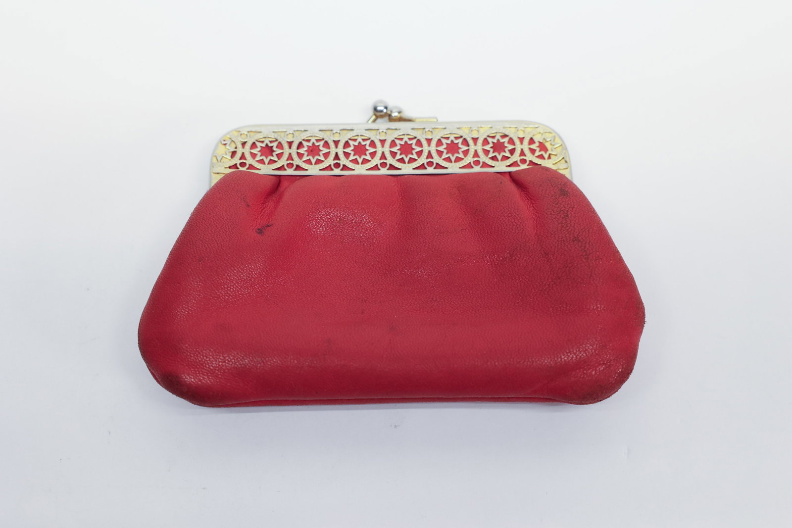 Red Leather Kiss-Lock Coin Purse, Filigree: Description:Vintage red leather coin purse/clutch with a decorative silver-tone pierced metal frame, featuring a repeating star-and-circle filigree pattern over the red leather beneath. Fitted with a 