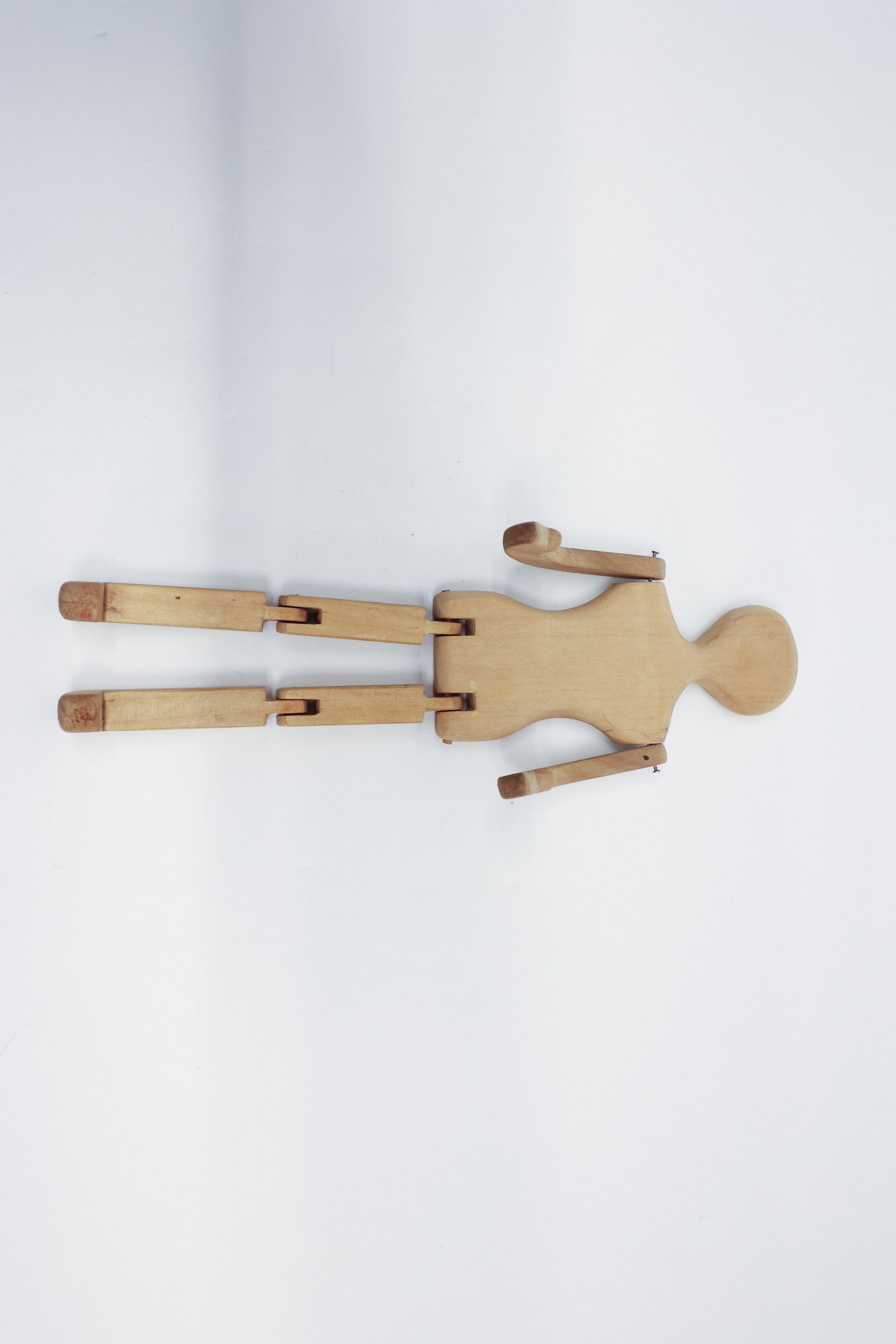 Antique Wooden Jointed Doll Body/Mannequin: Description:Hand-shaped wooden articulated figure form, with a carved oval head, shaped torso, and jointed wire-pinned arms, each limb made of turned wooden segments connected by tab-and-slot joints a