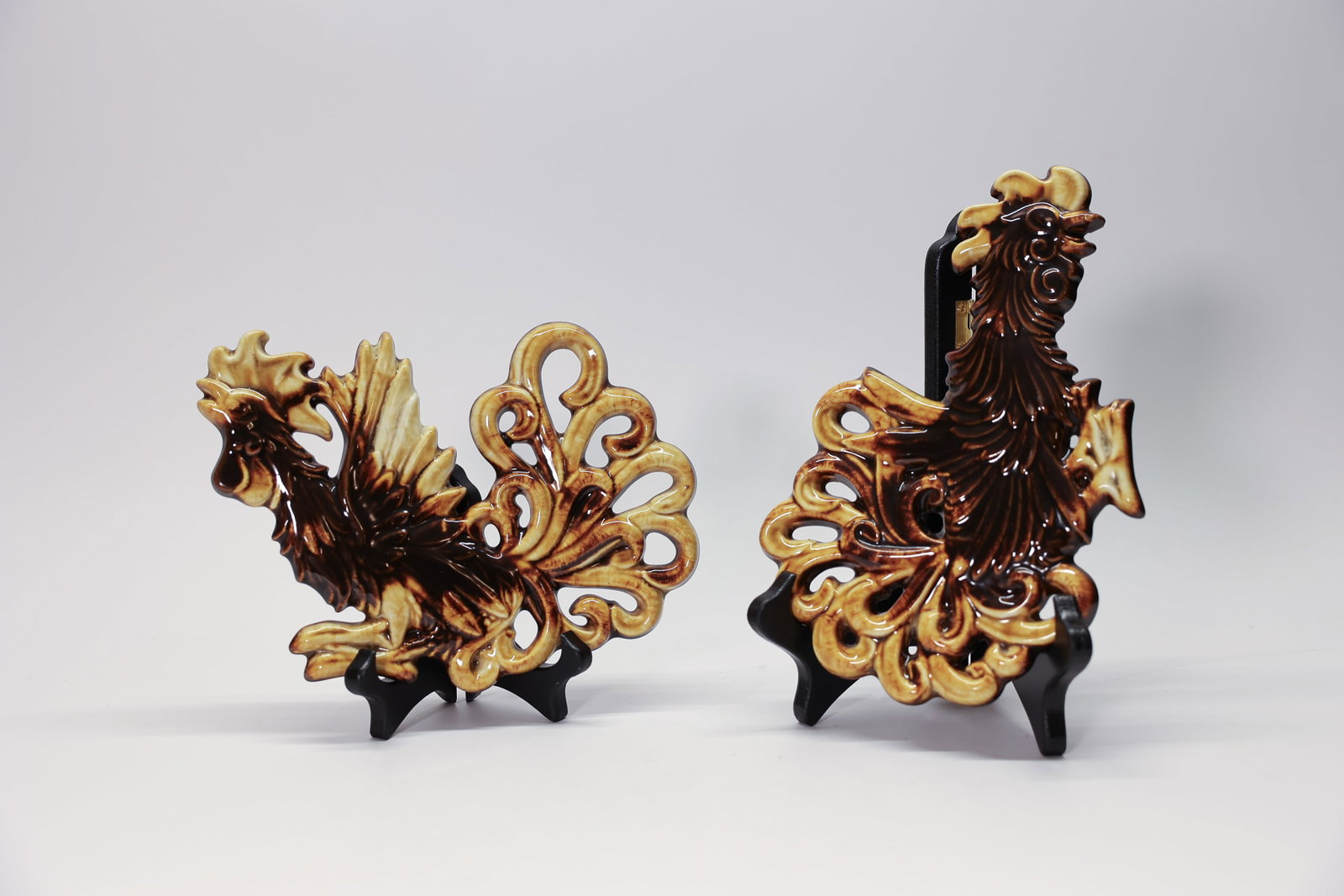 Set of Ceramic Wall Decor Roosters: Set of two cast ceramic wall hanging roosters. Mid century kitchen decor production pottery. Marked MS on the back. One is a little warped and the other one is flat. They are each 8 1/2 inches long 6