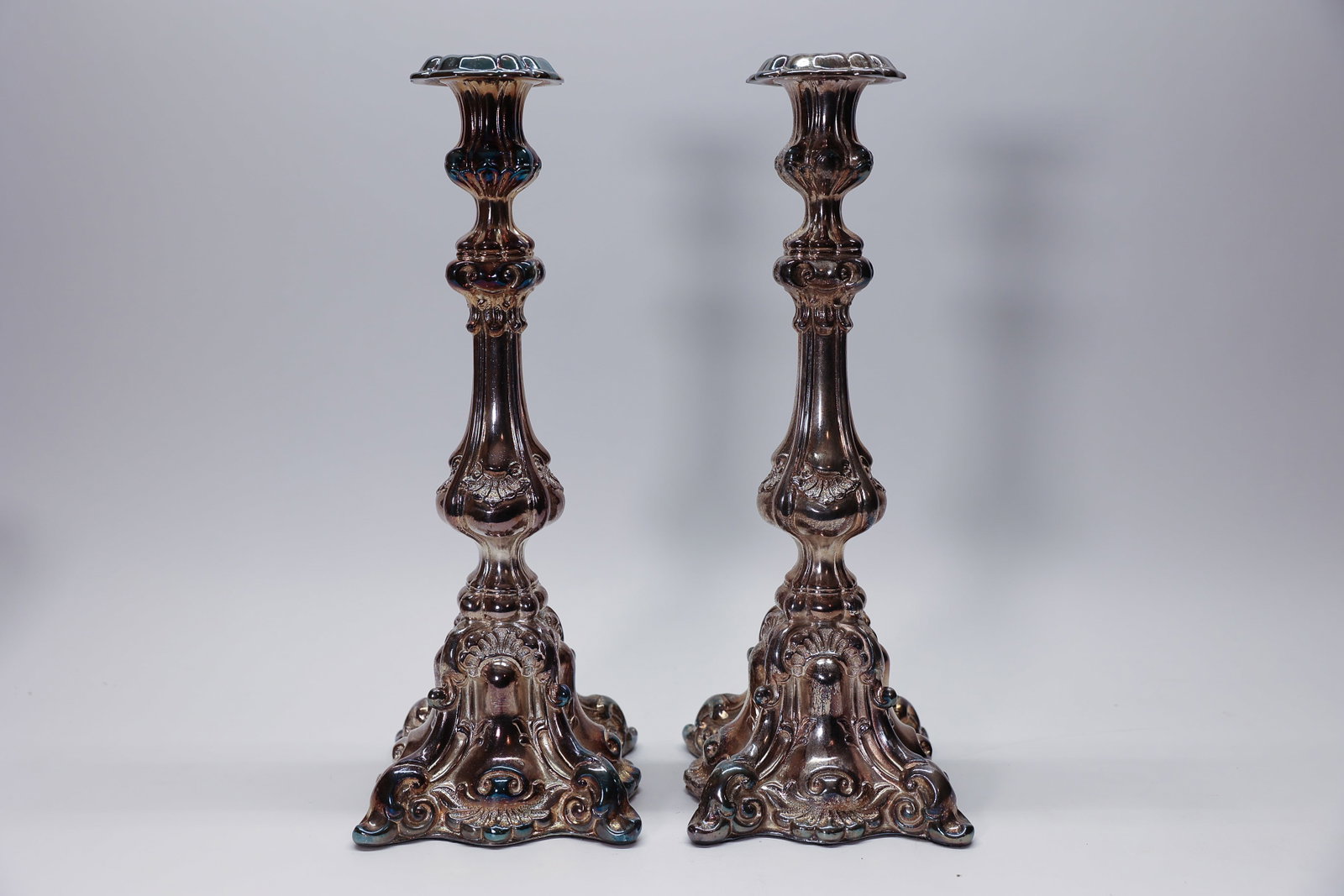 Giverny Pair Rococo Style Silver Plate Candlestick: Description:Pair of tall, ornately cast candlesticks in the Rococo revival style, with a scalloped trumpet drip-pan top, a shaped baluster stem with shell and scroll relief, and a tri-form scrolled