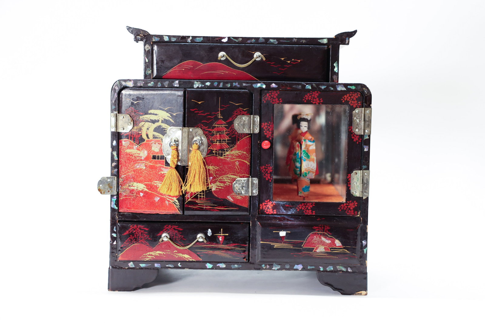 Japanese Lacquered Musical Jewelry Box, Geisha: Large cabinet style jewelry box with rotating Geisha doll. Music box works and Geisha rotates! See photos for condition report. 9 1/4” tall x 9 1/4” wide x 4 3/4” deep.Dimensions: