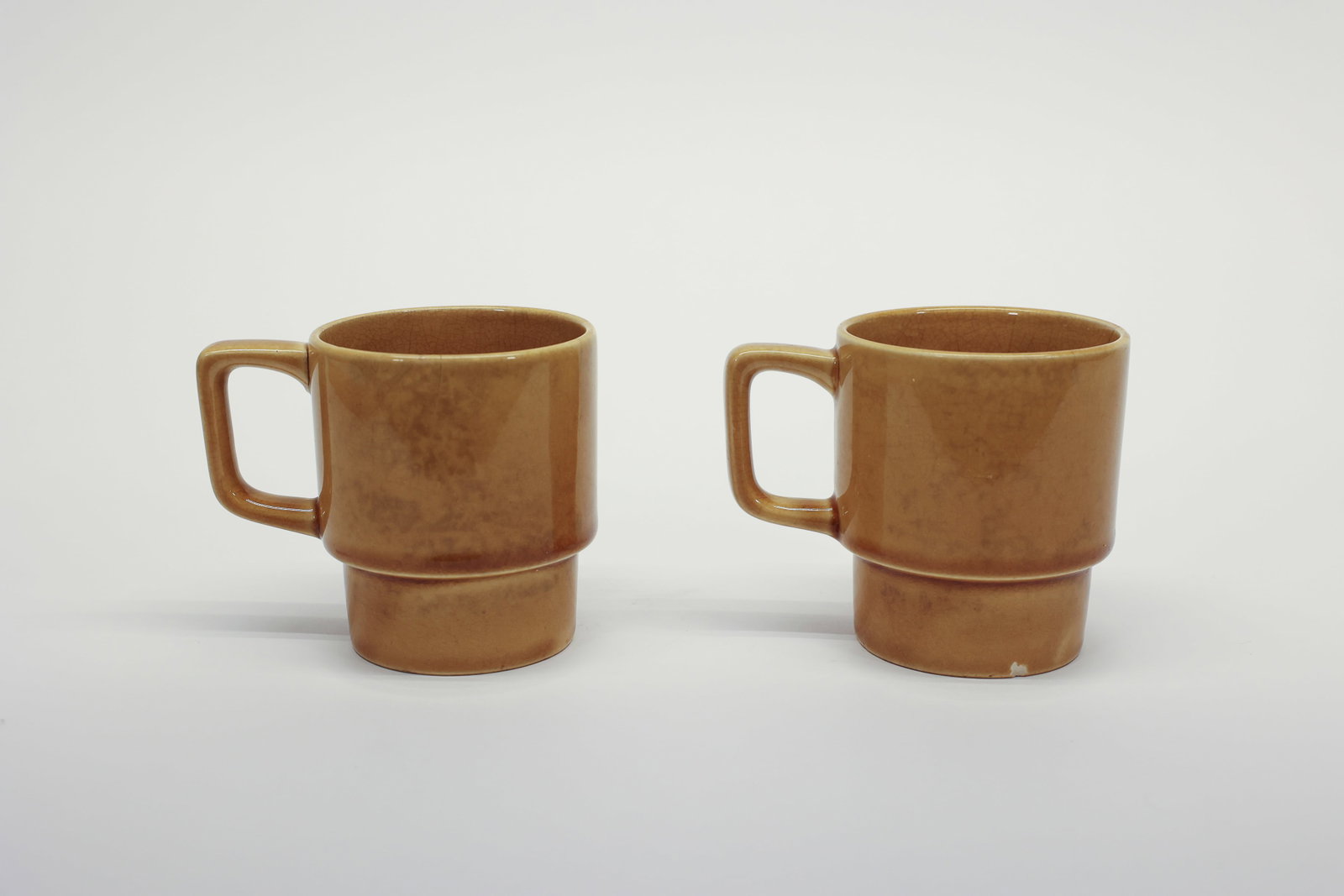 Japanese Tan Glazed Cafe Mug Set: Matching pair of vintage 1970s mid-century modern stoneware coffee mugs, expertly crafted in Japan. This highly collectible set features a distinctive retro stacking silhouette with functional tiered