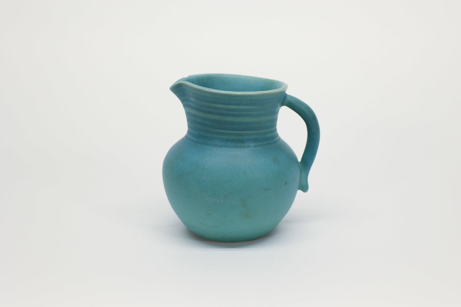 Van Briggle Pottery Turquoise Pitcher: Authentic Van Briggle Pottery pitcher in the classic bulbous form with a wide pouring spout and graceful curved handle. Features the pottery's signature soft matte turquoise-green glaze with subtle ho
