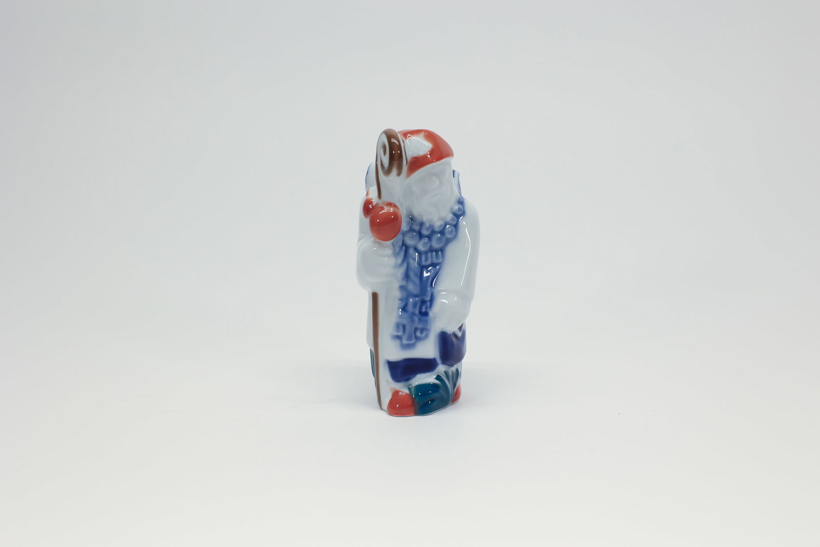 Sargadelos Spain Porcelain Pilgrim Figurine: Charming hand-painted porcelain figurine by Sargadelos, the renowned ceramics manufacturer from Galicia, Spain. Depicts a bearded pilgrim figure wearing a red cap and blue-striped cape, carrying a