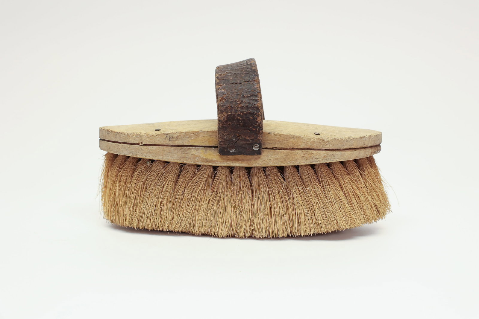 Wooden Scrub Brush, Leather Handle: Wonderful antique wooden scrub brush featuring dense natural bristles set into a shaped wooden base, with a hand-formed leather strap handle secured by vintage screws. The pointed oval wooden body