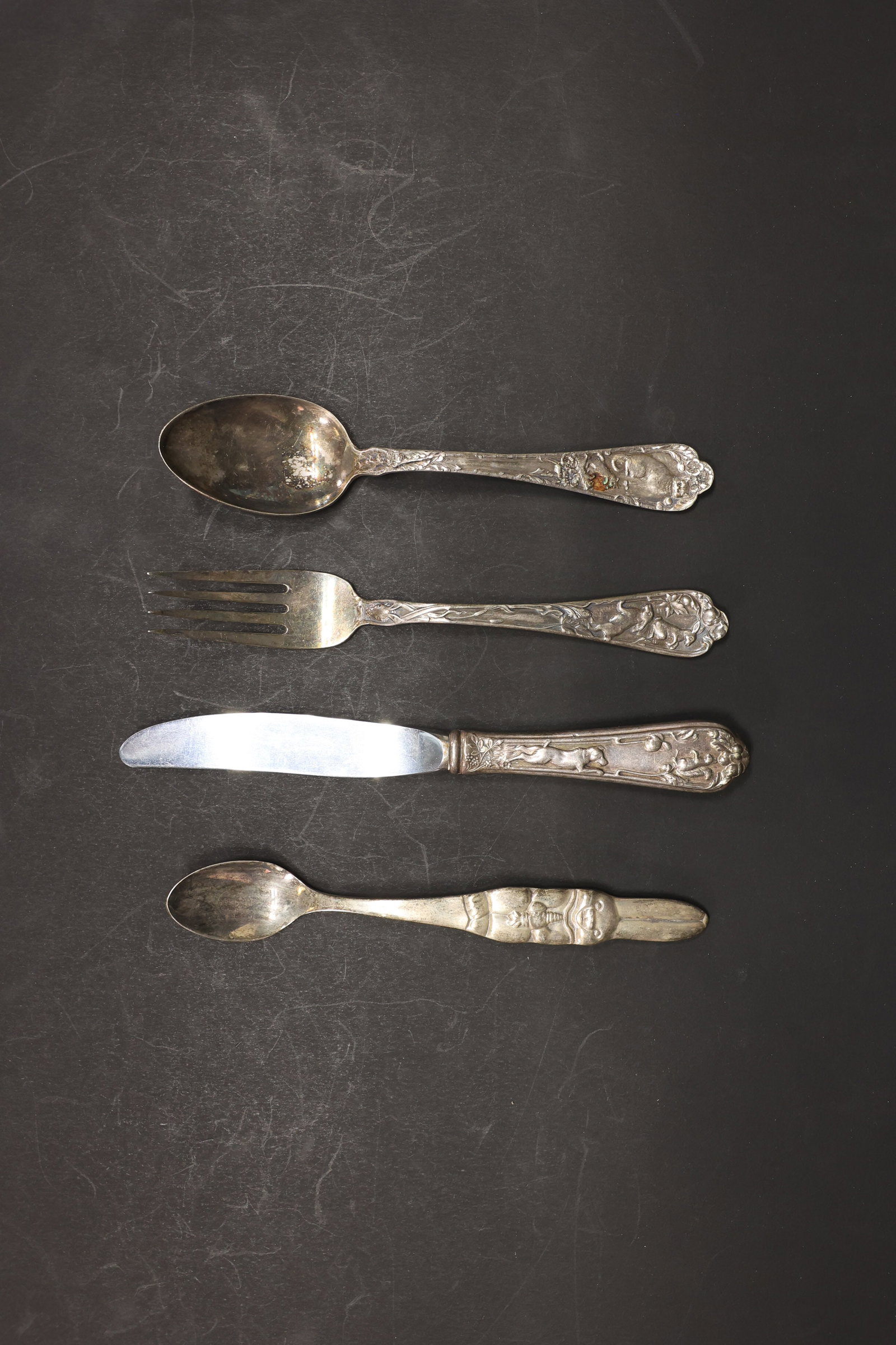 Reed & Barton "Animal" Silverplate Child's Set: Vintage Reed & Barton silverplate child's flatware, "Animal" pattern, 4 pieces: teaspoon, fork, knife, and small spoon. Each handle deeply embossed with a different woodland animal scene — running