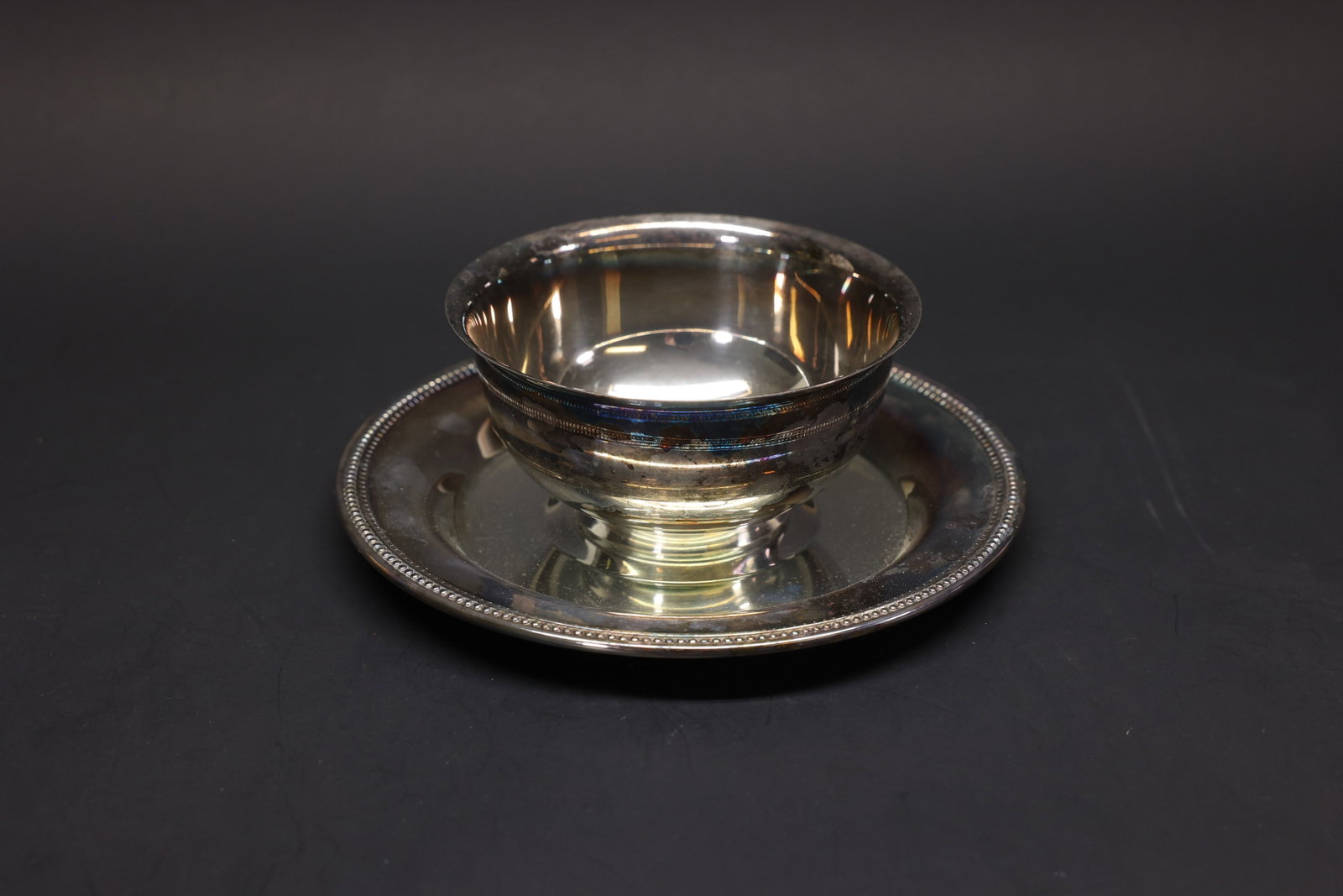 Oneida Silver-Plate Bowl with Underplate: Footed round bowl with matching beaded-rim underplate, silver plate. Plain form with a wide flared rim, ribbed pedestal foot. Marked "Oneida" on the underside.Dimensions: H: 2.5", W: 7.25"