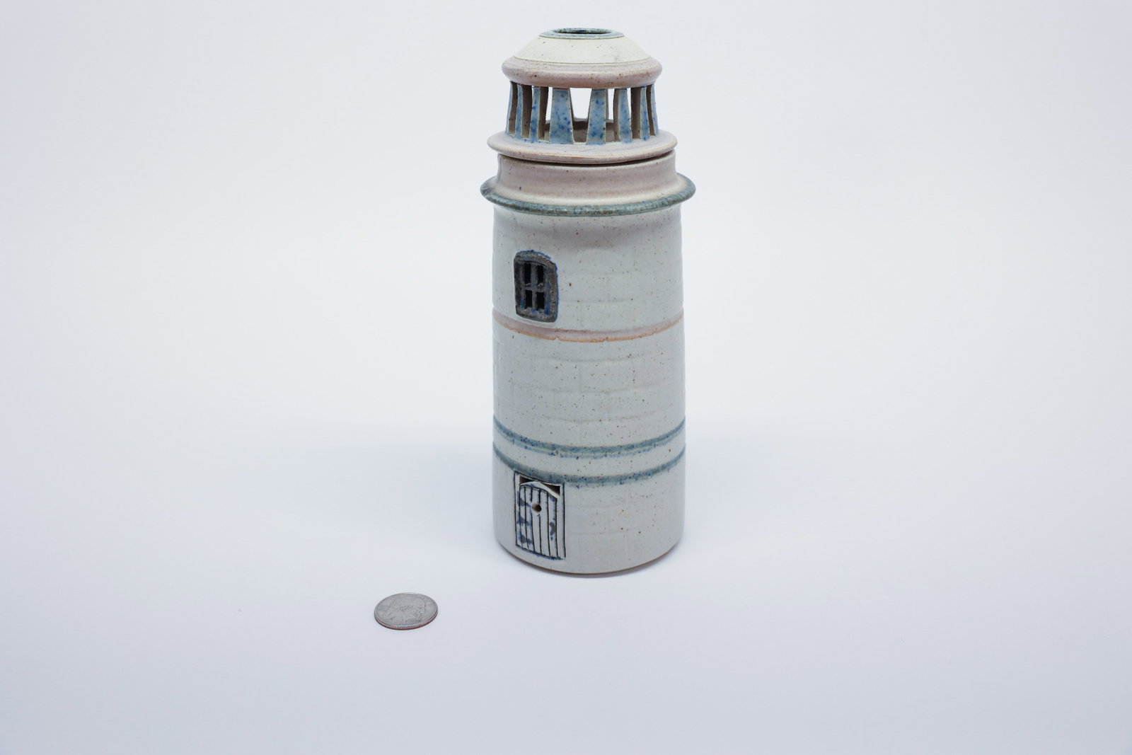 Studio Pottery Lighthouse Figural Lamp Gill's Rock: Hand-built stoneware lighthouse-form candle holder lamp with a cylindrical body textured with an incised brick pattern and banded in blue-glaze stripes. Applied door and window details picked out in b