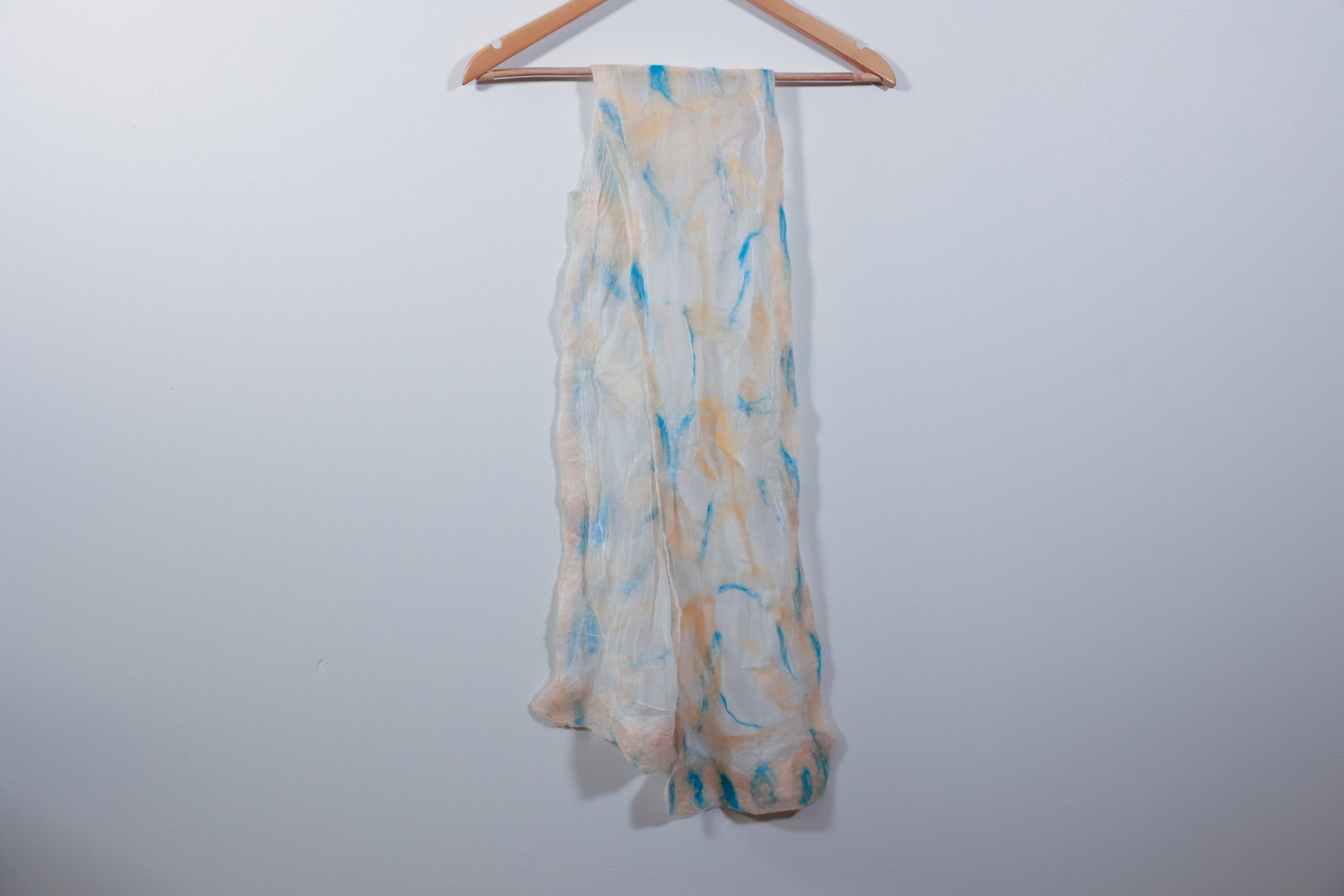 Nuno Felted Art Silk Scarf, Blue & Peach Abstract: Handmade nuno-felted scarf combining sheer silk with wisps of wool fiber in blue and peach tones, worked into an abstract, cloud-like pattern. Fine sparkle/glitter inclusions throughout. Raw, unfinish