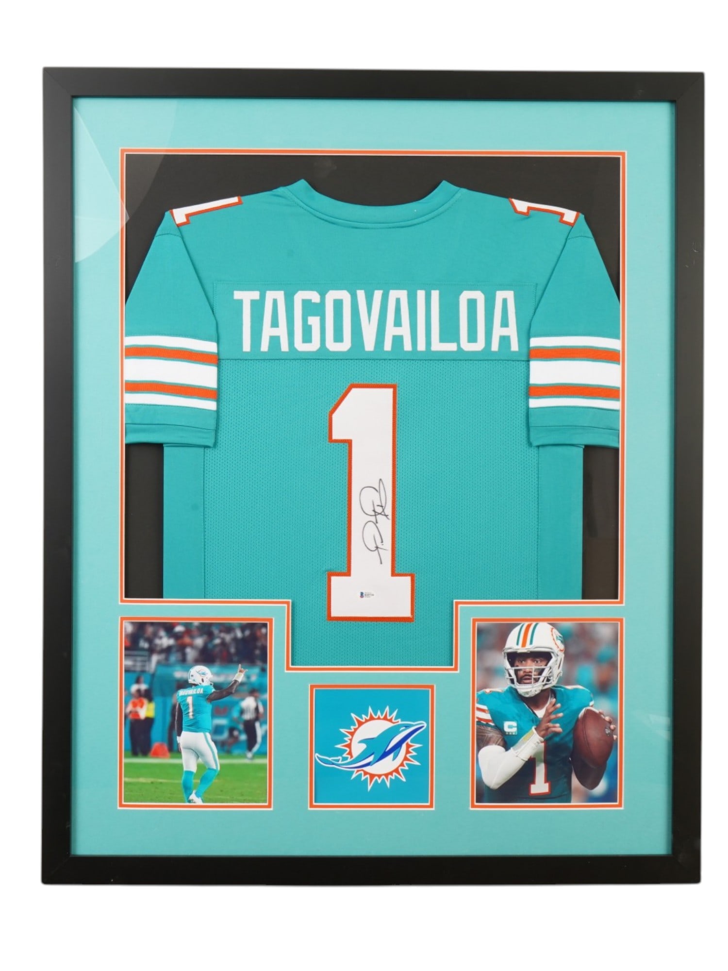 FRAMED TUA TAGOVAILOA SIGNED MIAMI DOLPHINS JERSEY BECKETT: This premier memorabilia centerpiece features a custom-framed Miami Dolphins jersey hand-signed by star quarterback Tua Tagovailoa. A foundational talent for the franchise, Tua led the NFL in passer