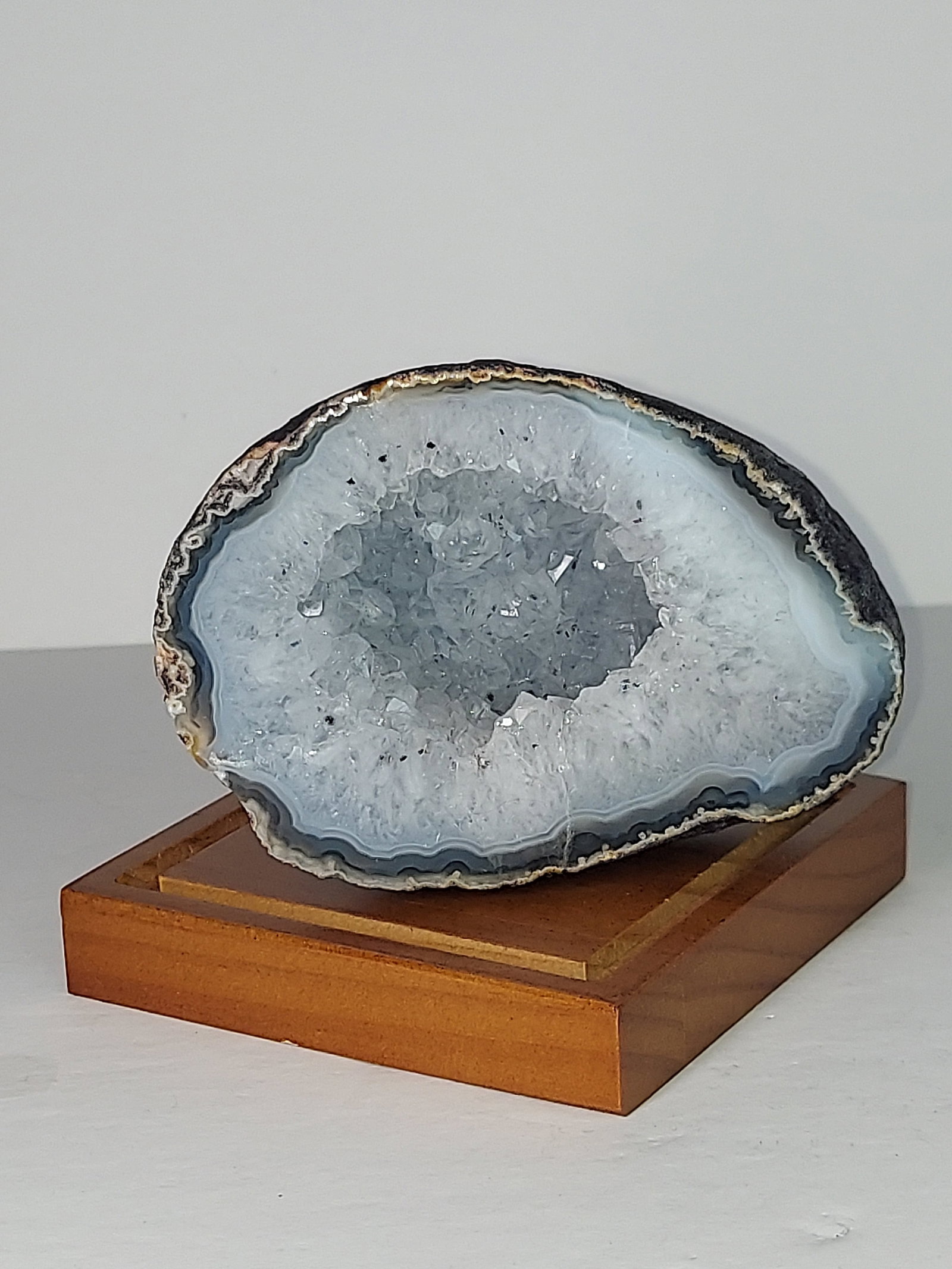 Agate with Quartz Crystal Cave Face Polished: Face-Polished Agate with Quartz Crystal Cave This natural agate specimen features a beautifully face-polished surface that reveals soft gray, white, and charcoal banding surrounding a sparkling