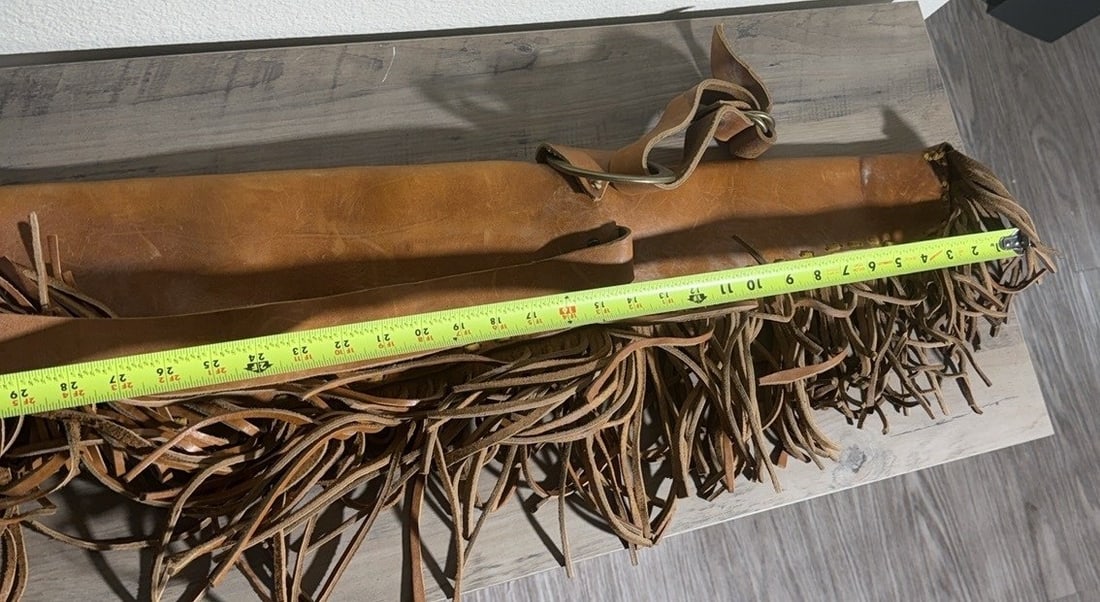 Fringed Leather Rifle Scabbard, c.1920s-1960s: Fringed brown leather rifle scabbard with ring hardware. This tooled leather scabbard is designed to carry a long rifle on horseback or in a saddle setting, featuring decorative fringe along its