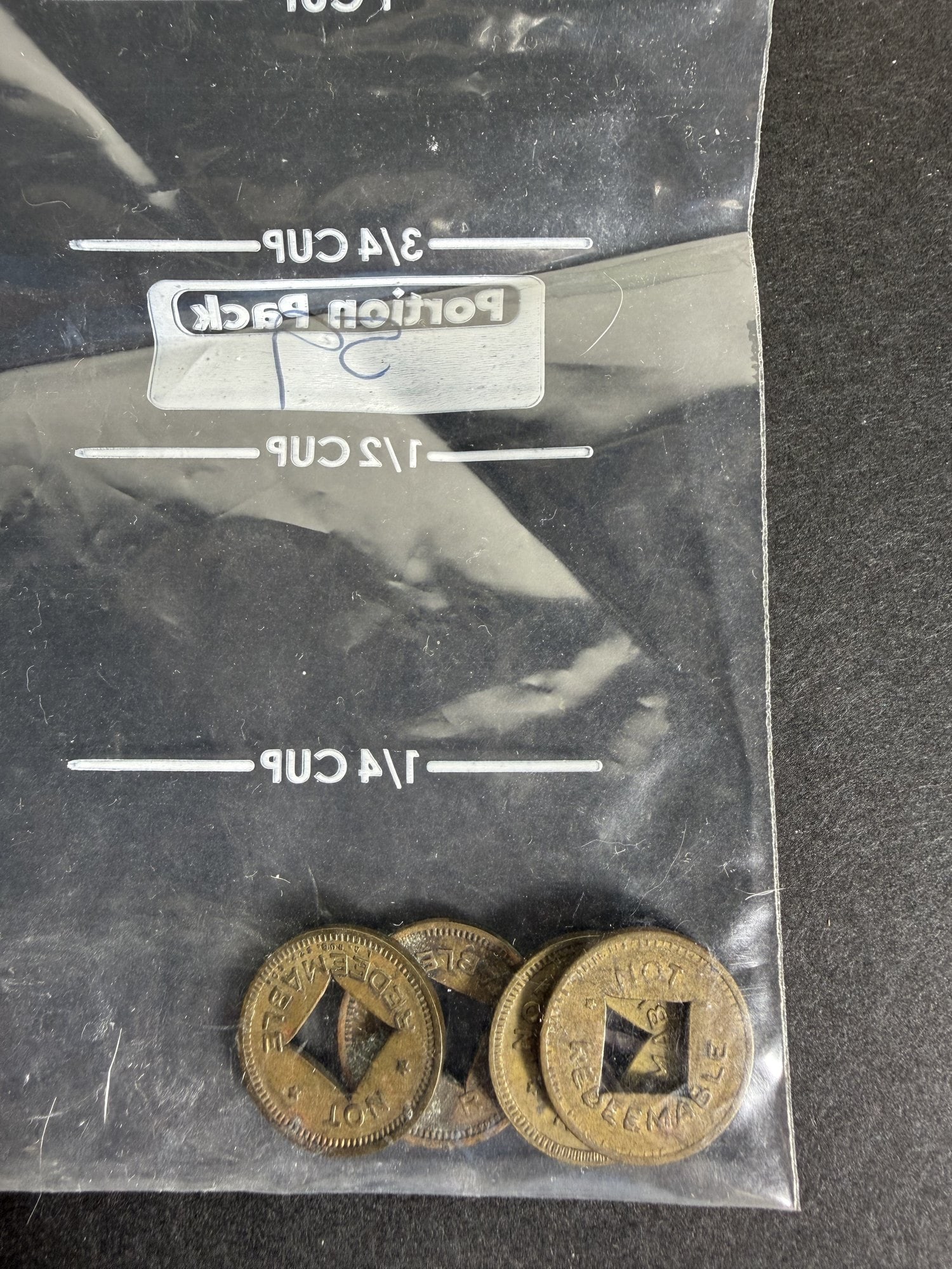 Brass Trade Token Pair, Lettering Partial: Pair of brass or bronze holed tokens with partially visible lettering. This lot consists of two holed tokens in a brass or bronze tone, each showing a large letter K along with additional lettering th