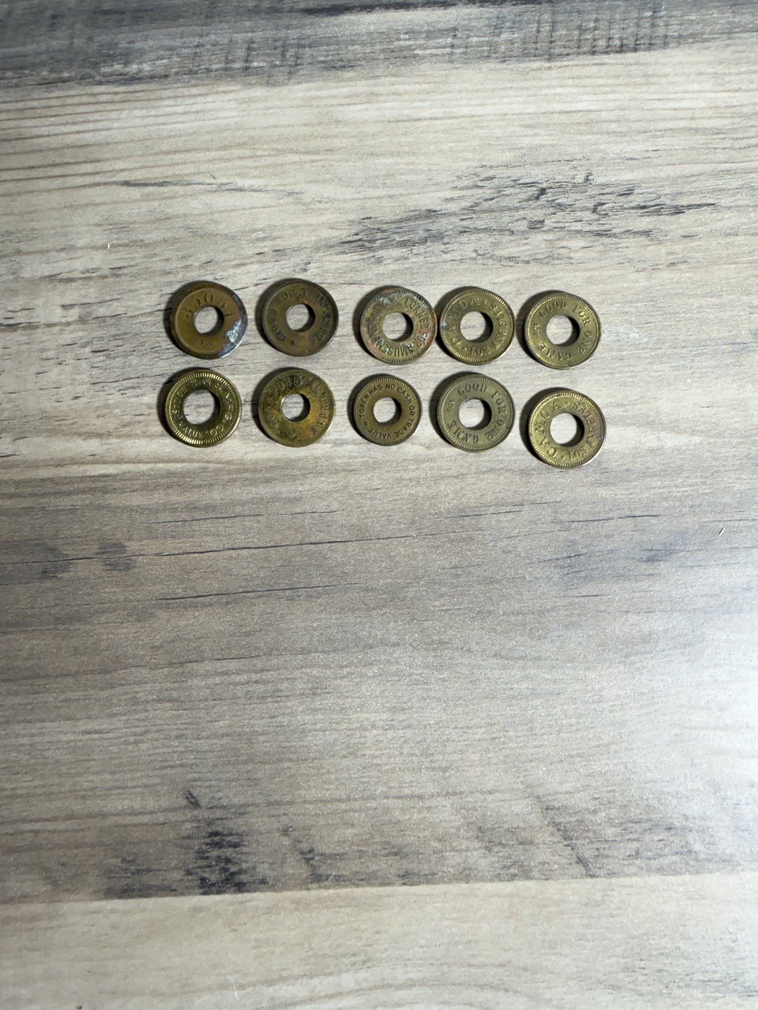 LA Amusement & Trade Token Mix, Brass, 10 Pcs: Mixed lot of 10 brass amusement, trade, and entertainment tokens from the Los Angeles area, circa mid-20th century. All tokens are round brass with center holes and milled borders. The group includes 