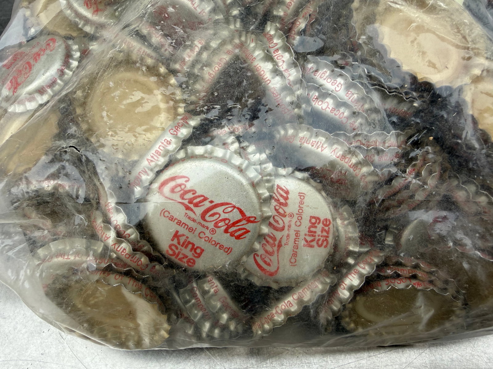1960s Coca-Cola “King Size” Bottle Crowns – 500+ Unused NOS Bottling Stock: An unusual surviving collection of more than 500 vintage Coca-Cola “King Size” bottle crowns, preserved as unused New Old Stock (NOS) and never applied to bottles. Dating to the mid-20th centu