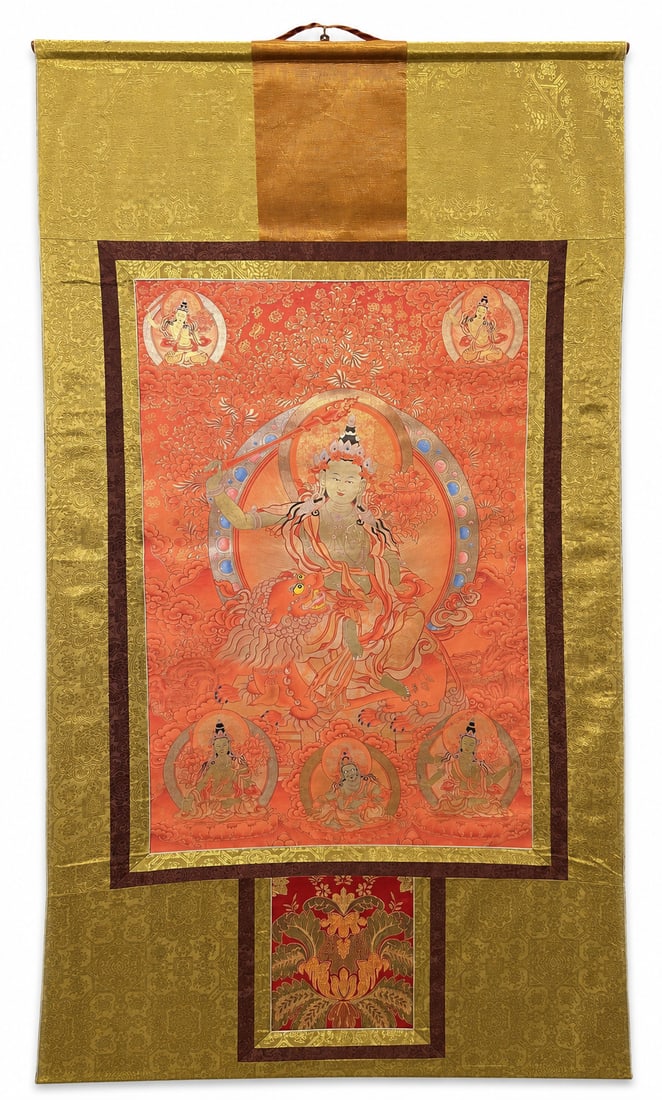 Large Red-Ground Thangka of Manjushri with Jambhala, Circa 1980–1990s: A large Tibetan thangka depicting Manjushri seated upon a lion, raising the sword of wisdom beside a lotus supporting a sacred text. Four subsidiary bodhisattva figures surround the central deity, wit
