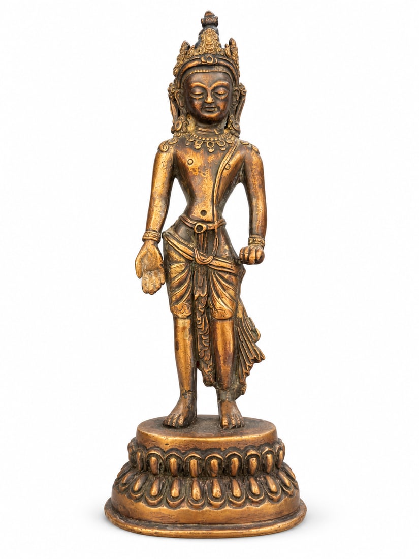 Nepalese-Style Copper-Alloy Standing Figure of Avalokiteshvara, Qing Dynasty: A Nepalese-style copper-alloy standing bodhisattva, identified as Avalokiteshvara, wearing an elaborate crown, circular earrings, necklaces and a patterned dhoti with cascading folds. The right hand i