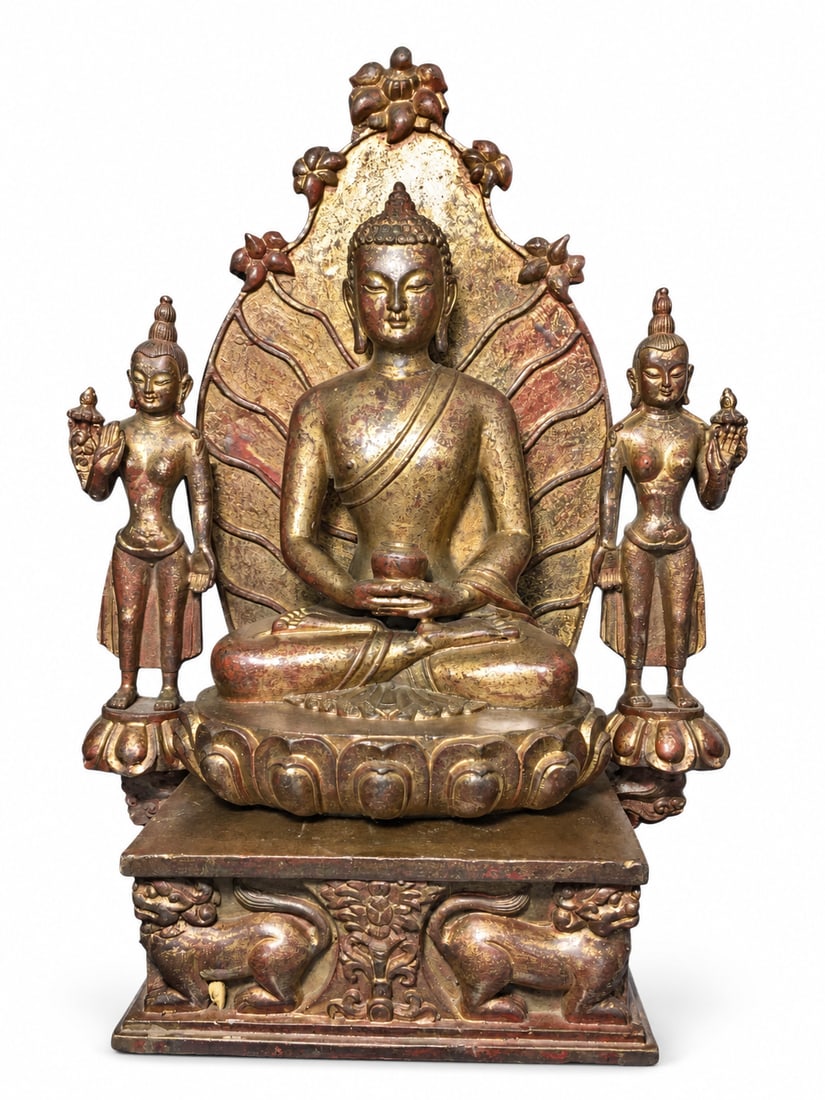 Buddha with Two Standing Attendants on a Lion Throne: A Buddhist sculptural group depicting a seated Buddha flanked by two standing attendants. The central figure wears monastic robes and holds a small vessel in the lap, seated on a lotus pedestal before