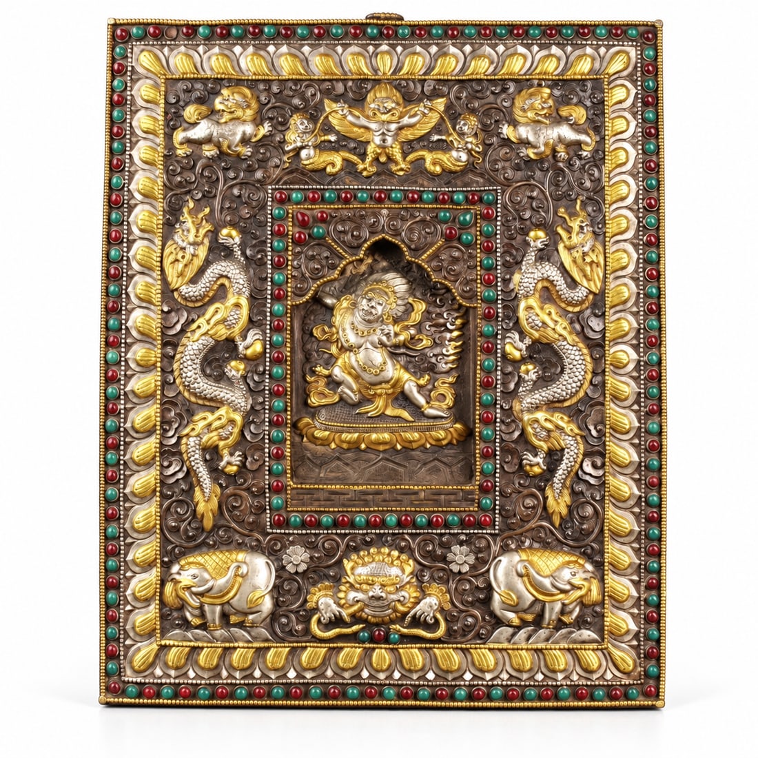 13th/14th Century, Tibetan-Style Inlaid Metal Relief Panel, Vajrapani: A large Tibetan-style metal relief panel depicting a wrathful Buddhist deity, probably Vajrapani, within a flame surround and an arched central recess. The elaborate frame incorporates a Garuda figure
