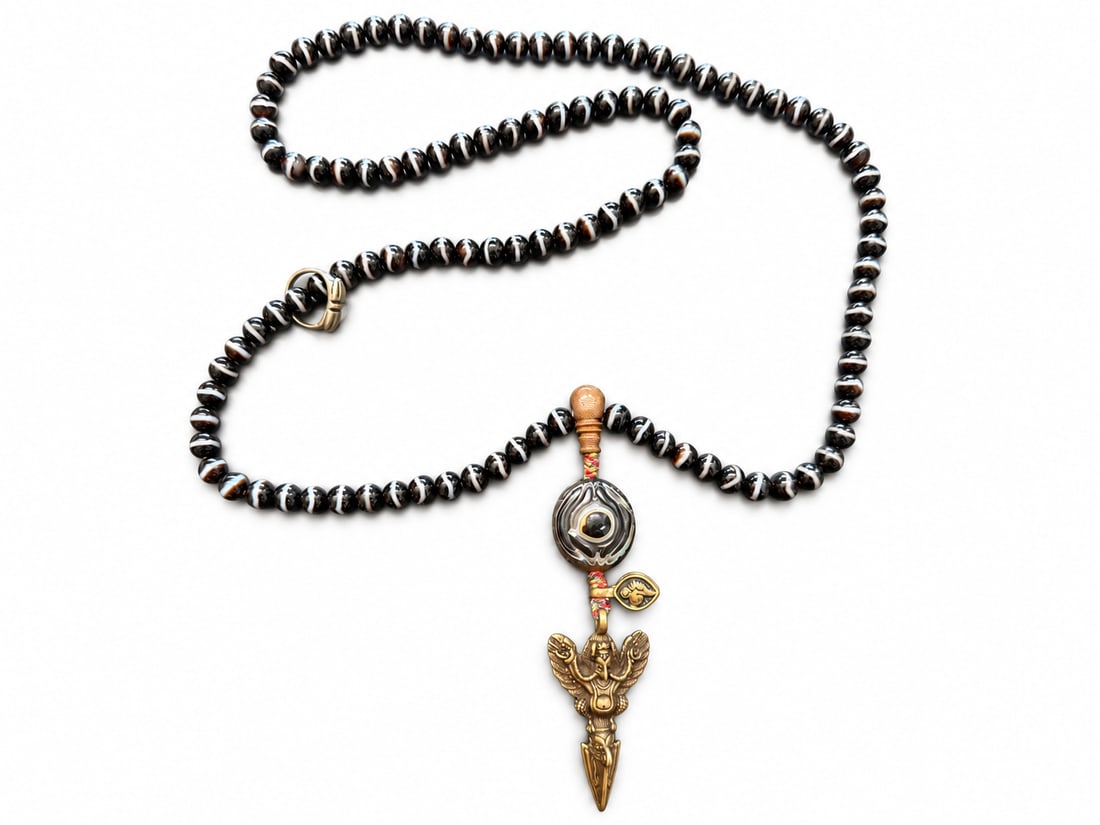 Rare 108-Bead Banded Agate Mala with Garuda Pendant and Ring, Qing Dynasty: A strand of 108 Medicine Buddha prayer beads, accompanied by an old Garuda pendant, a large Medicine Buddha bead described by the owner as old and rare, and a small vajra ring. The dark beads display 