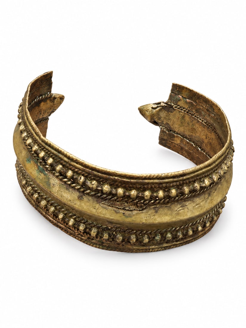 Tibetan Cuff Bracelet with Rope-Twist and Beaded Decoration, Qing Dynasty: A Tibetan cuff bracelet, described by the owner as an old example. The broad, open-ended band features a raised central ridge bordered by rope-twist ornament and rows of small rounded bosses. Its warm