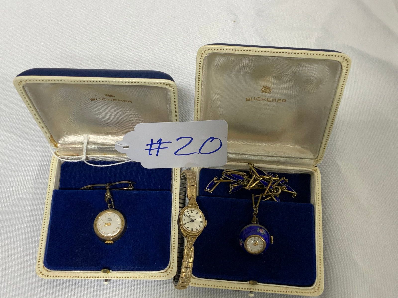 3 Ladies Watches: 3 ladies watches: 1st round blue enamel watch, 17 jewels, Swiss Bucherer, with matching enamel chain in fitted case. 2nd Bucherer 17 jewel Swiss watch on pin, orange enameling with gold stars on