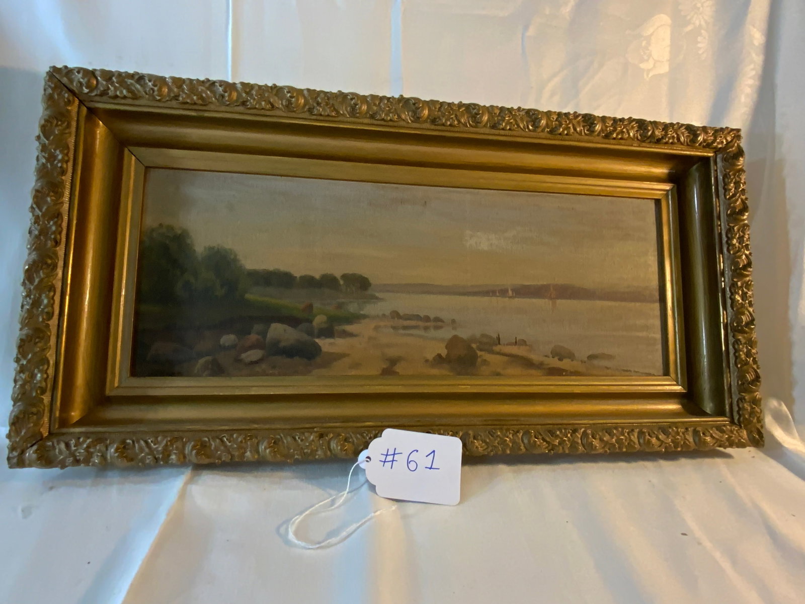 American School Painting: American School, signed lower left (illegible), oil on panel in gilt frame, shoreline of lake w/ sailboats & mountains. Good condition.