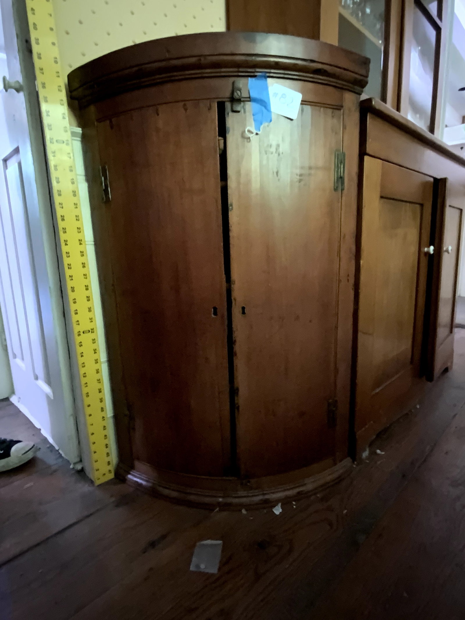 Corner Cupboard: Corner cupboard, old finish, rounded wooden doors, H hinges, 24" wide, 37 1/2" tall, circa 1790-1820. Fair condition.