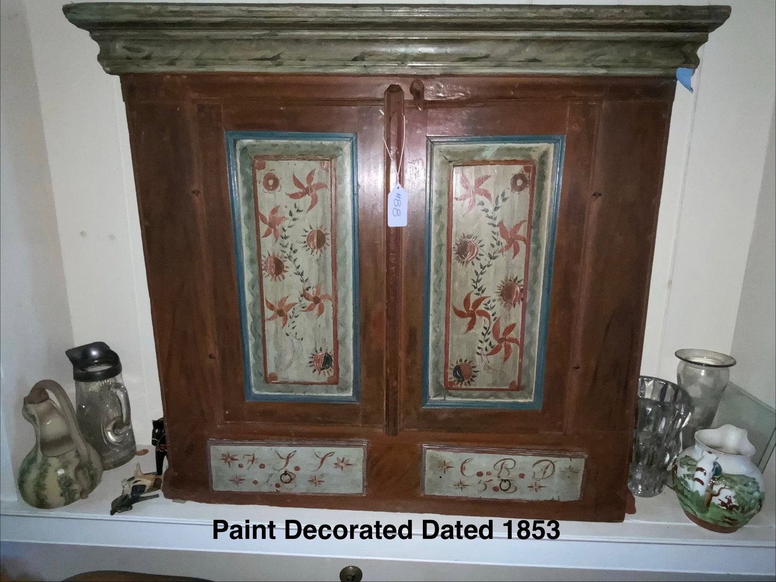 Hanging Wall Cupboard: Hanging wall cupboard in old paint and stencil, two doors on top with two small drawers on bottom, both drawers have initials stenciled on them, 40 inches wide, 37 inches tall, 12 inches deep. Good