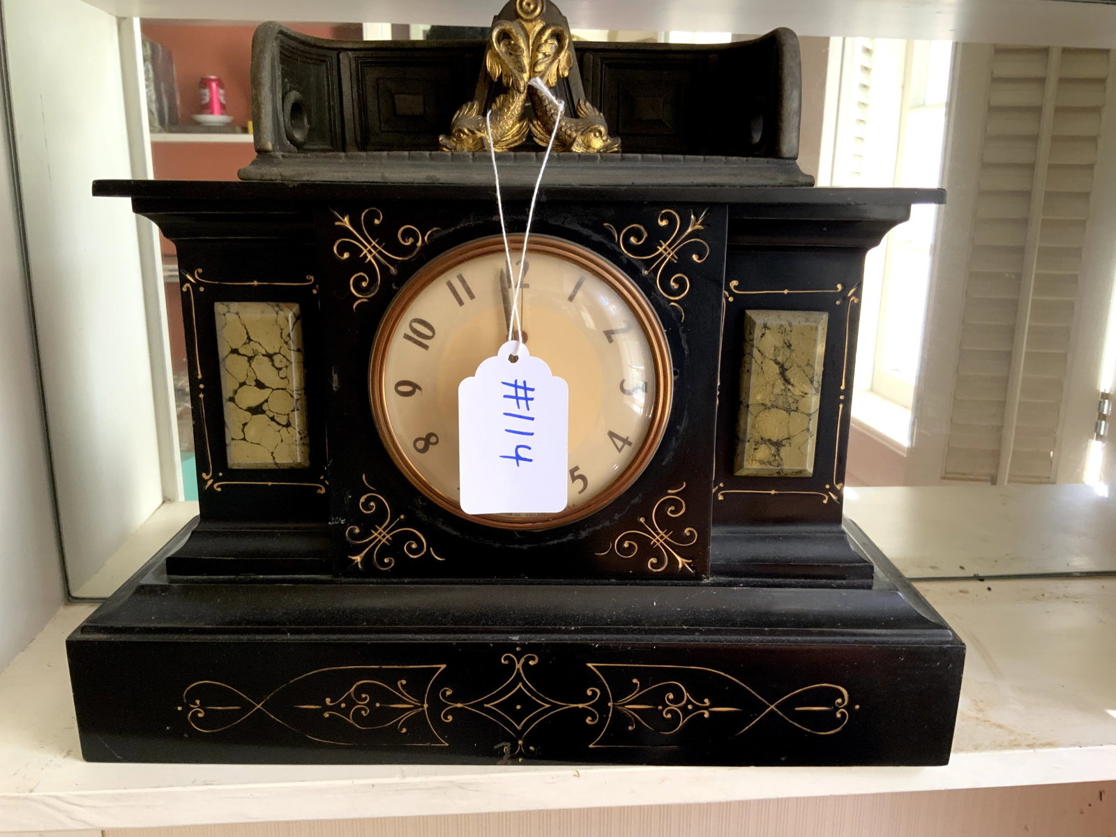 Marble Clock: Marble clock, brass dolphin decoration on top, gold painted inlay, electrified, 15" wide, 13" tall. Good condition.