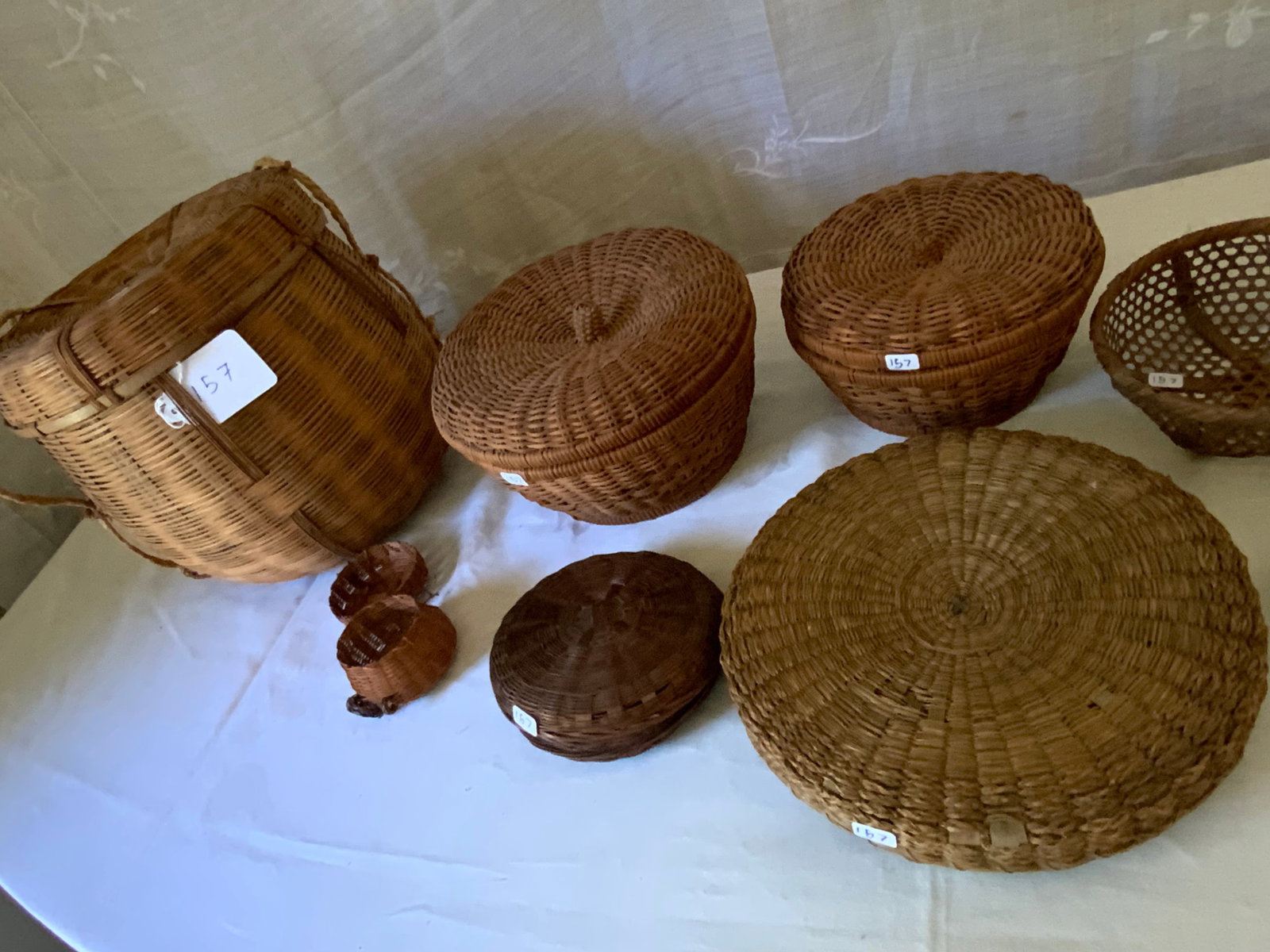 Baskets: Grouping of 11 baskets, 10 with lids, 1 open basket as-is, variety of age & condition. Overall good condition.