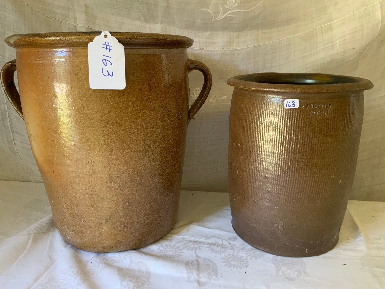 Crocks: 2 crocks: 1 two-handle, 14" tall, 12" wide; 1 Muskauer handleless, 11 1/2" tall, 9" wide, German crock. Good condition.