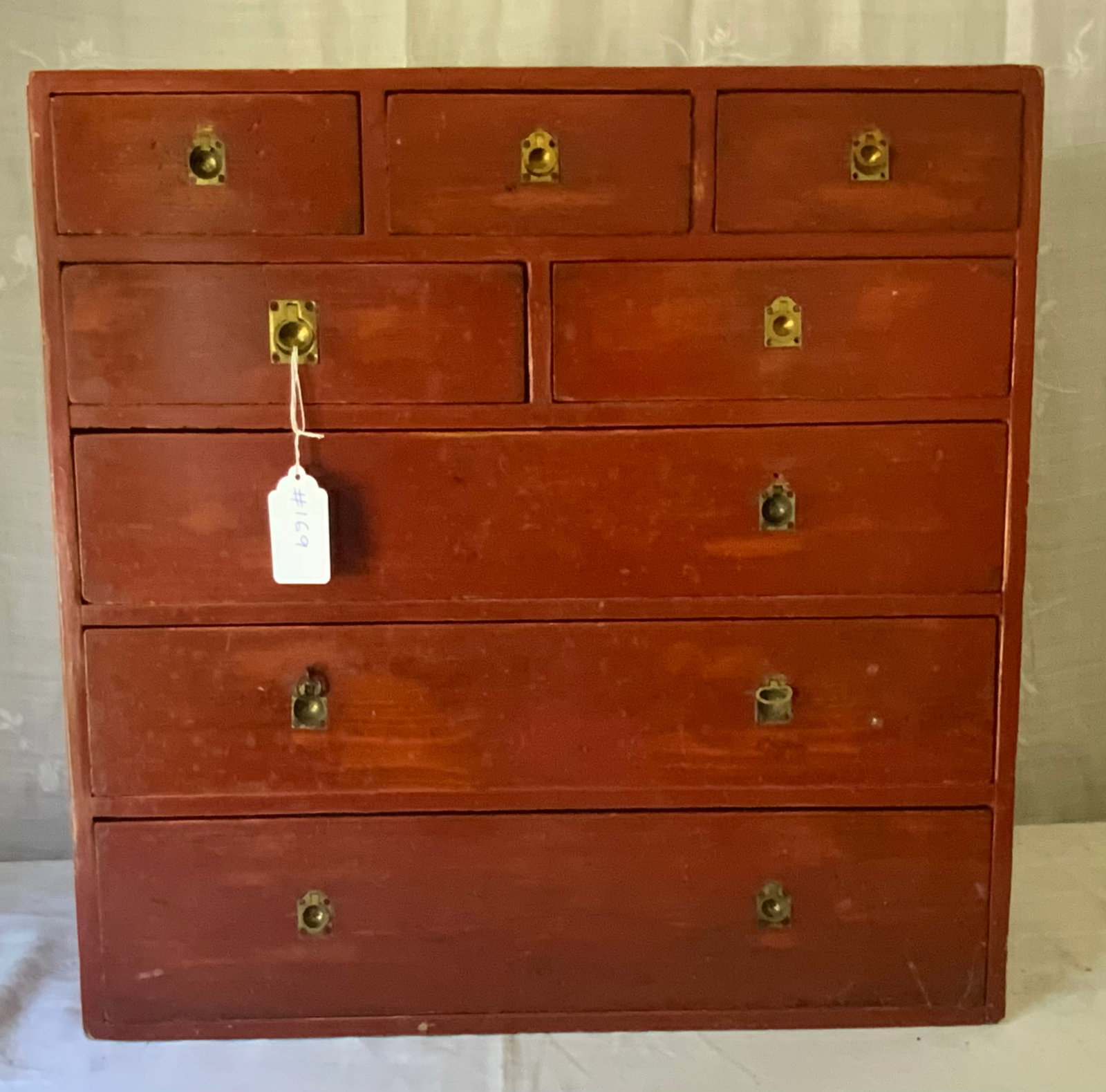 Red Finish Chest: Red finish 8-drawer chest, 24 inches tall, 24 inches wide, 10 1/2 inches deep, a few brass ring handles missing. Overall good condition.