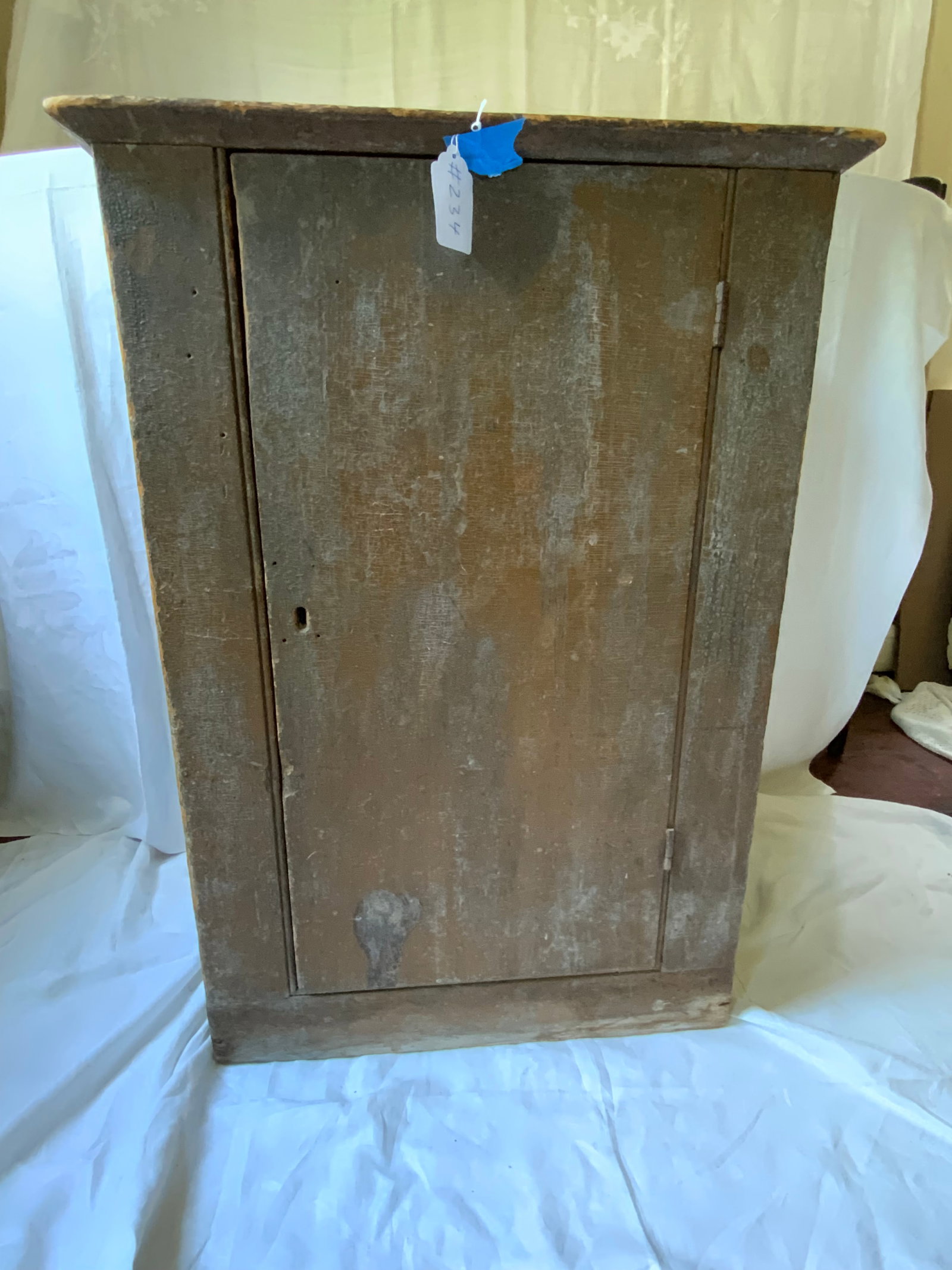 1-Door Cupboard: 1-door cupboard, old finish orange/tan, pine, 26" wide, 12 1/2 inches deep, 36 1/2" tall. Good condition.