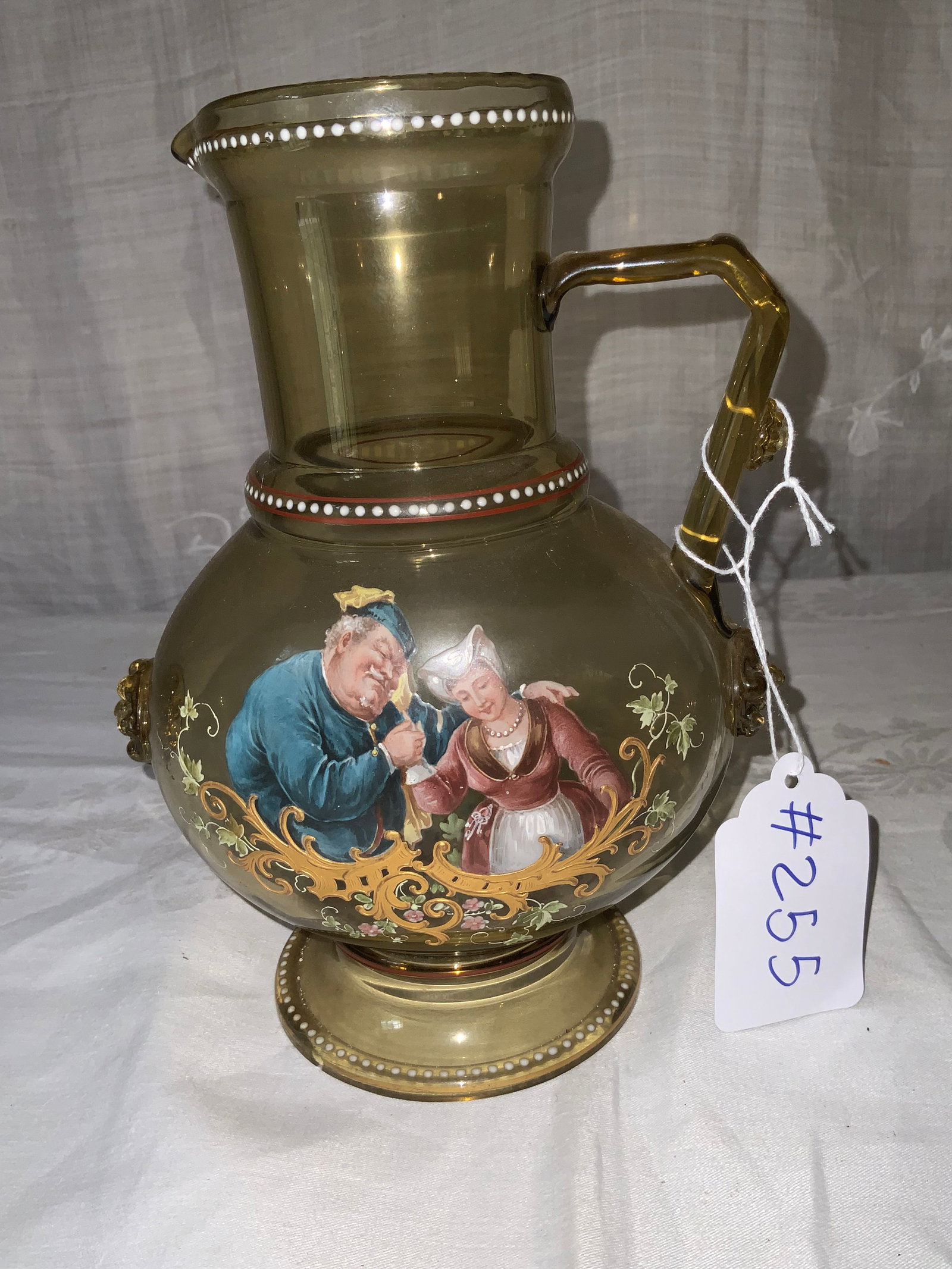 German Rhine Wine Pitcher: German Rhine wine pitcher, pale green, raised base, hand painted man and woman dancing, applied handle with rosettes, 9 inches tall, 7 inches wide. Good condition.