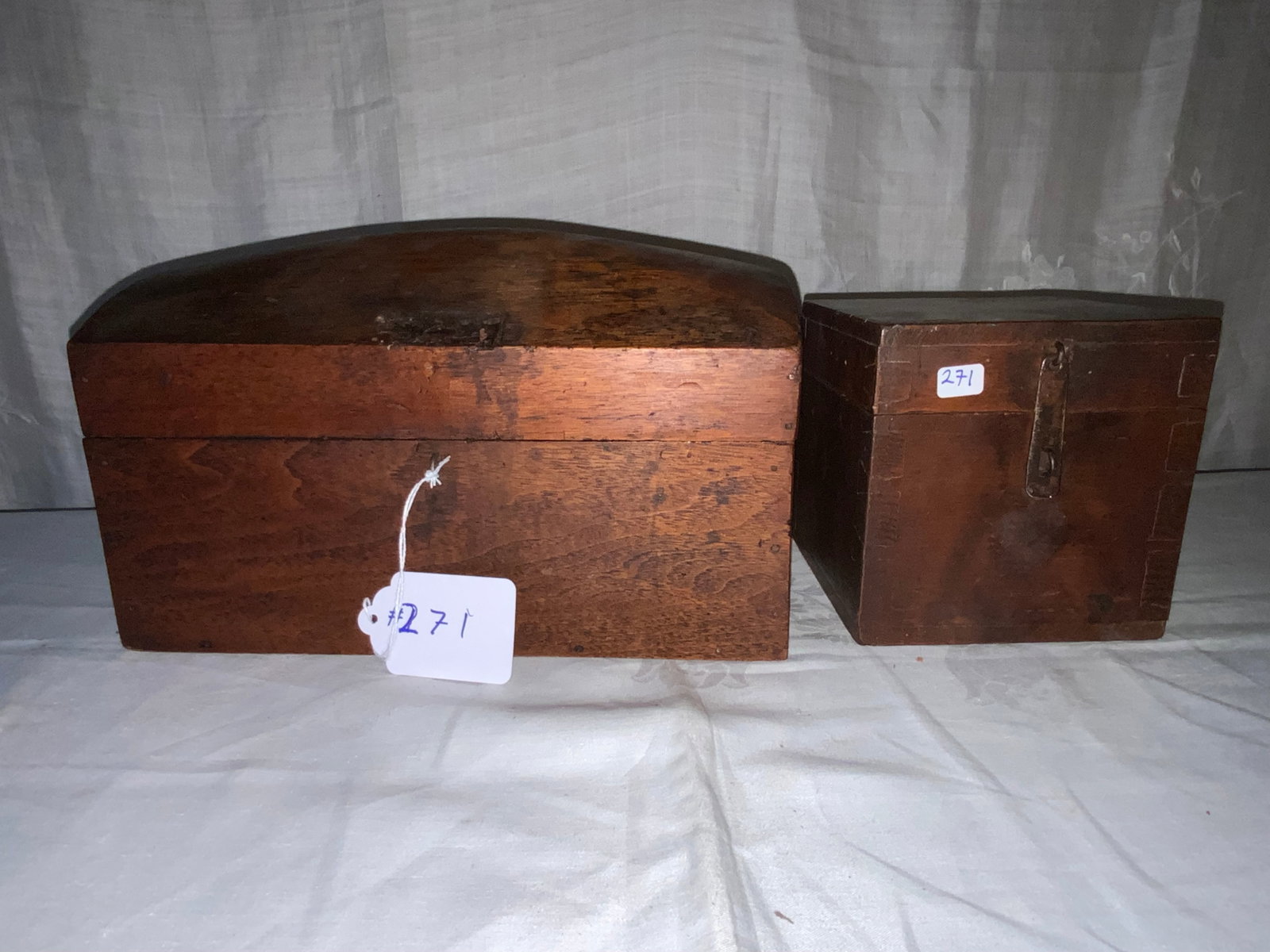 Wooden Boxes: 2 wooden boxes: 1 dome top w/ detached leather hasp inside, 12" wide by 6 1/2" deep, 6 1/2" tall; 2nd square mahogany w/ hasp, dovetailed, 5 1/2" cube. Fair condition.